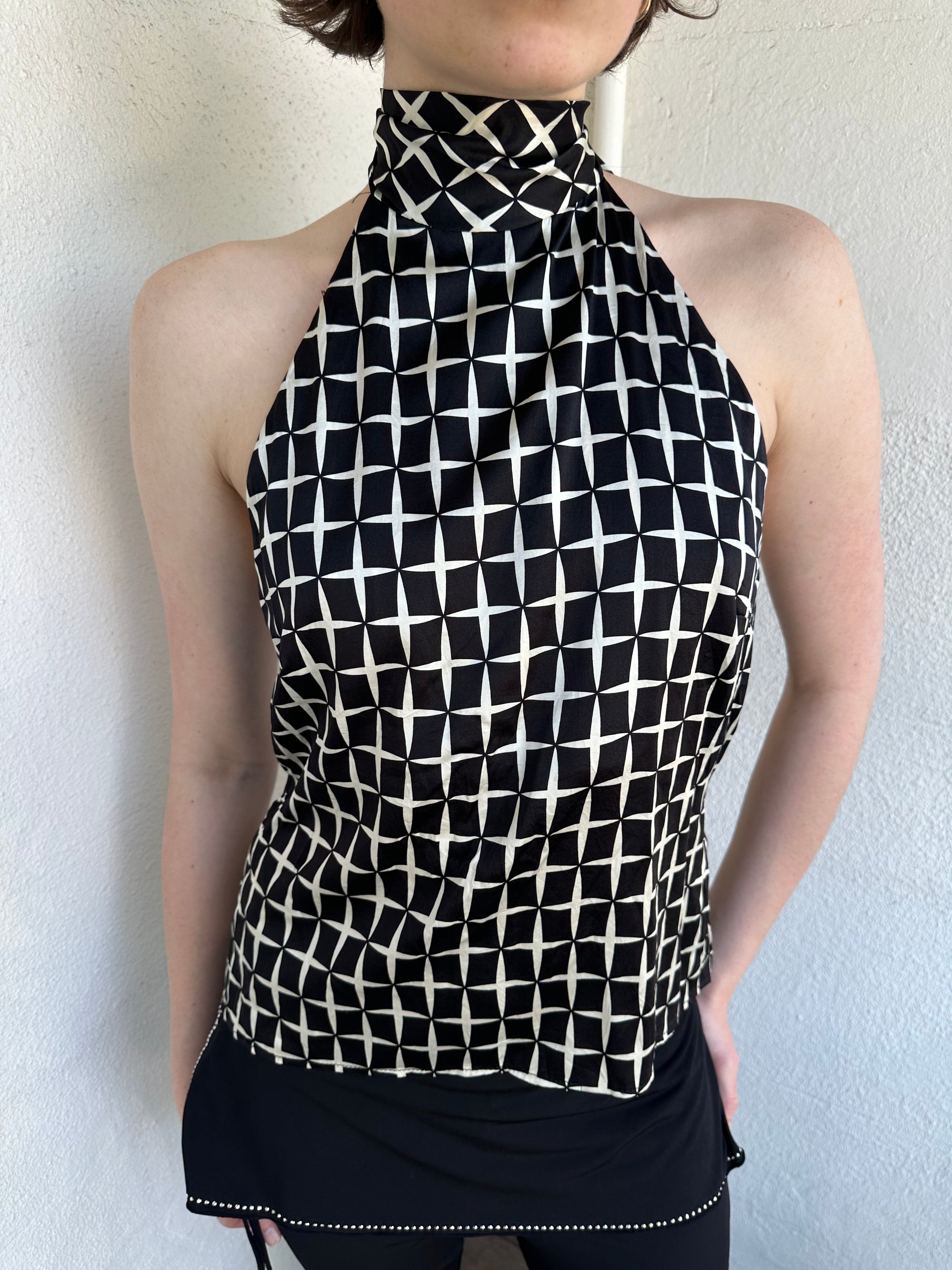 Woman Dressed in Y2K Black and white diamond pattern halter neck top featuring a striking geometric print with a flattering tie-back neckline.