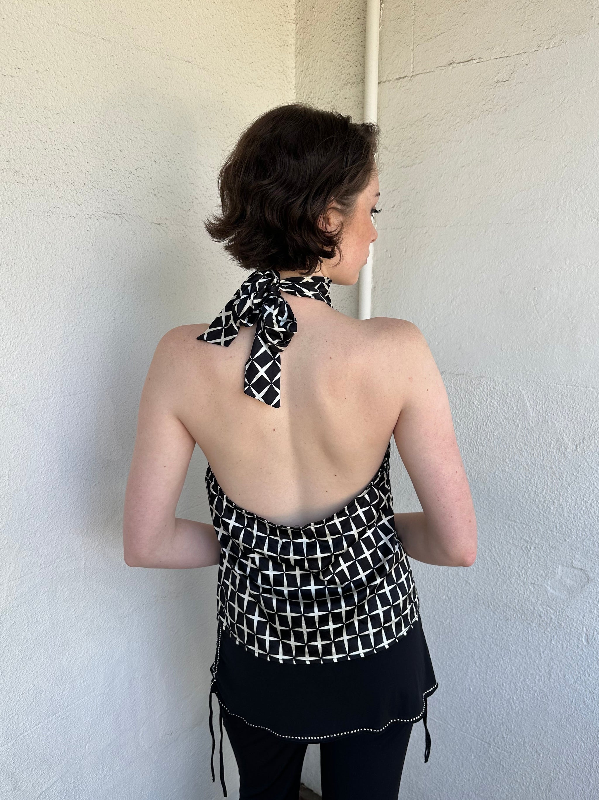 Woman Dressed in Y2K Black and white diamond pattern halter neck top featuring a striking geometric print with a flattering tie-back neckline.
