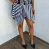 Woman Dressed in Y2K 00s Black and white stripe asymmetric skirt featuring a bold striped pattern and a hanky hem for a playful, flared silhouette.