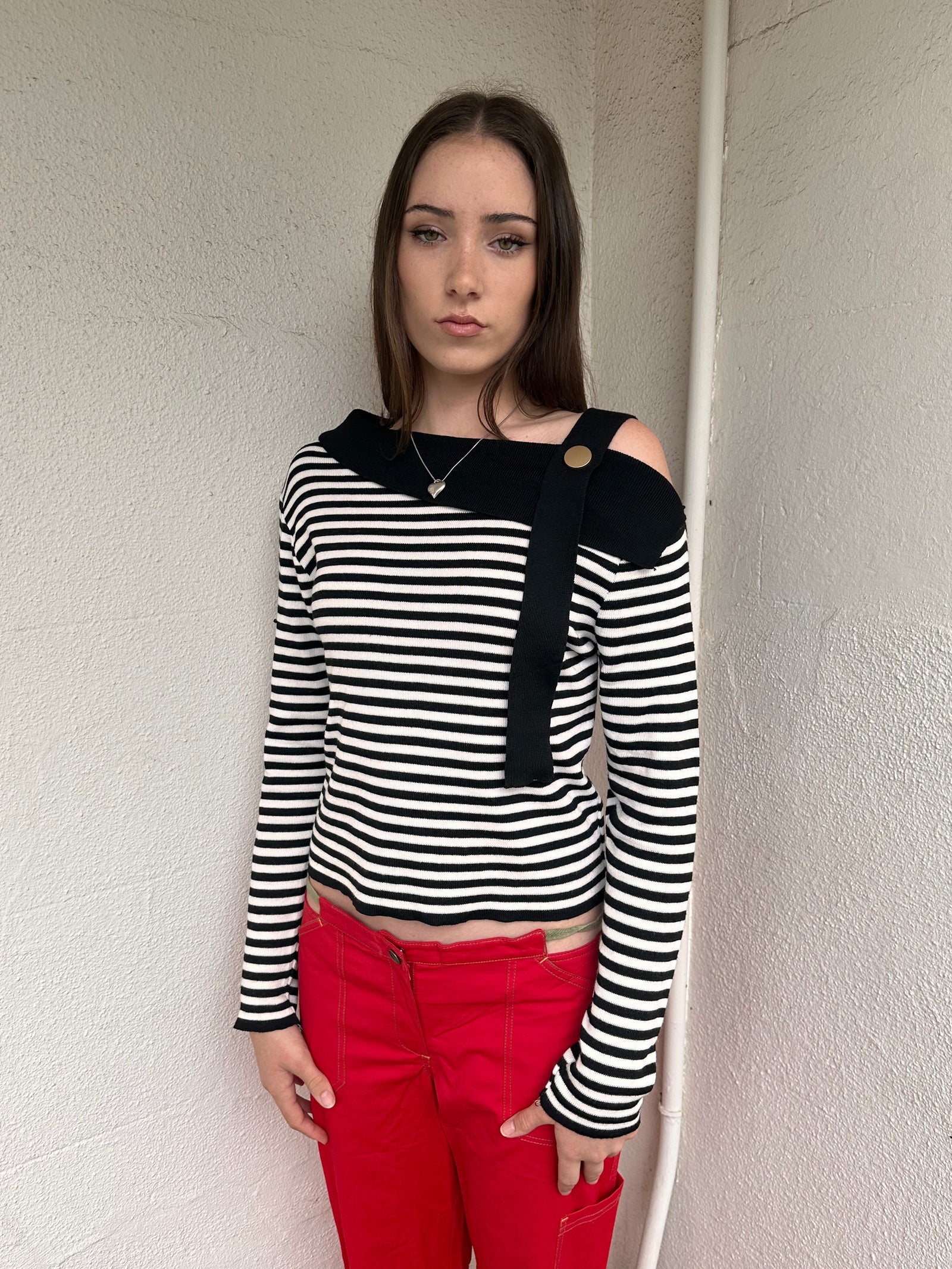 Women wearing a 00s Y2K lack and white stripe knitted top with an asymmetric collar and one-shoulder strap.