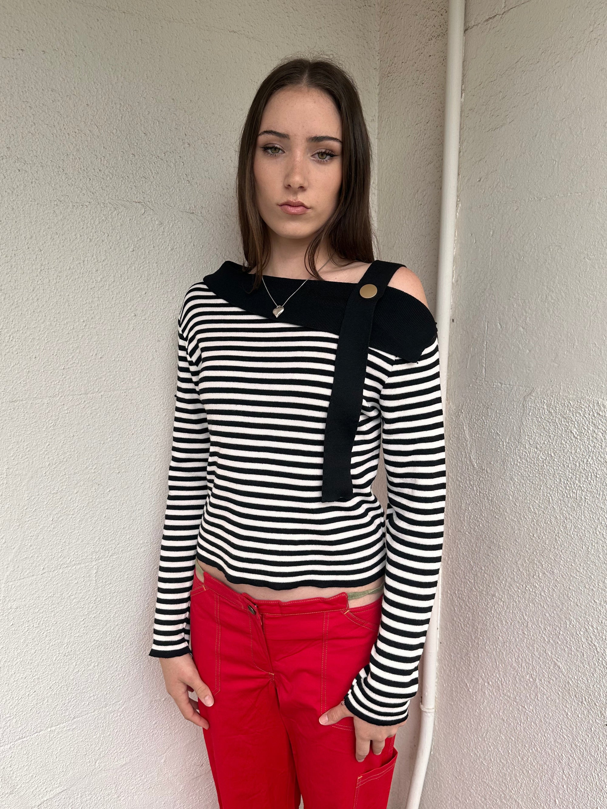 Women wearing a 00s Y2K lack and white stripe knitted top with an asymmetric collar and one-shoulder strap.