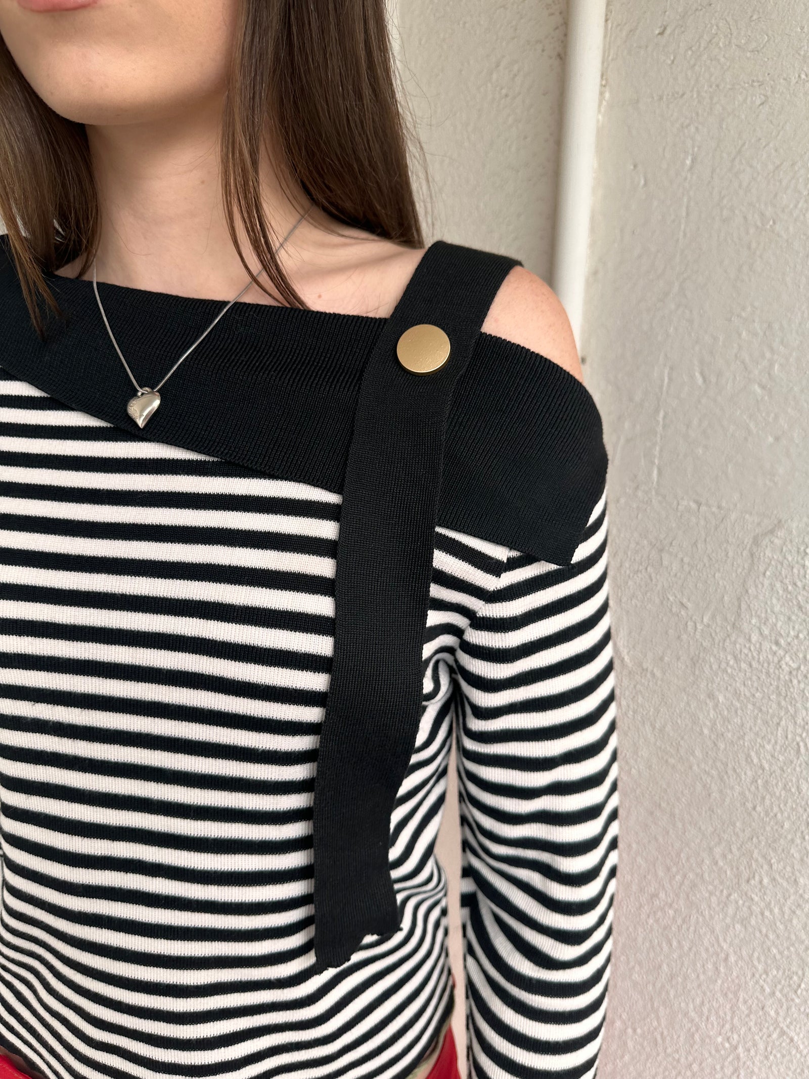 Women wearing a 00s Y2K lack and white stripe knitted top with an asymmetric collar and one-shoulder strap.