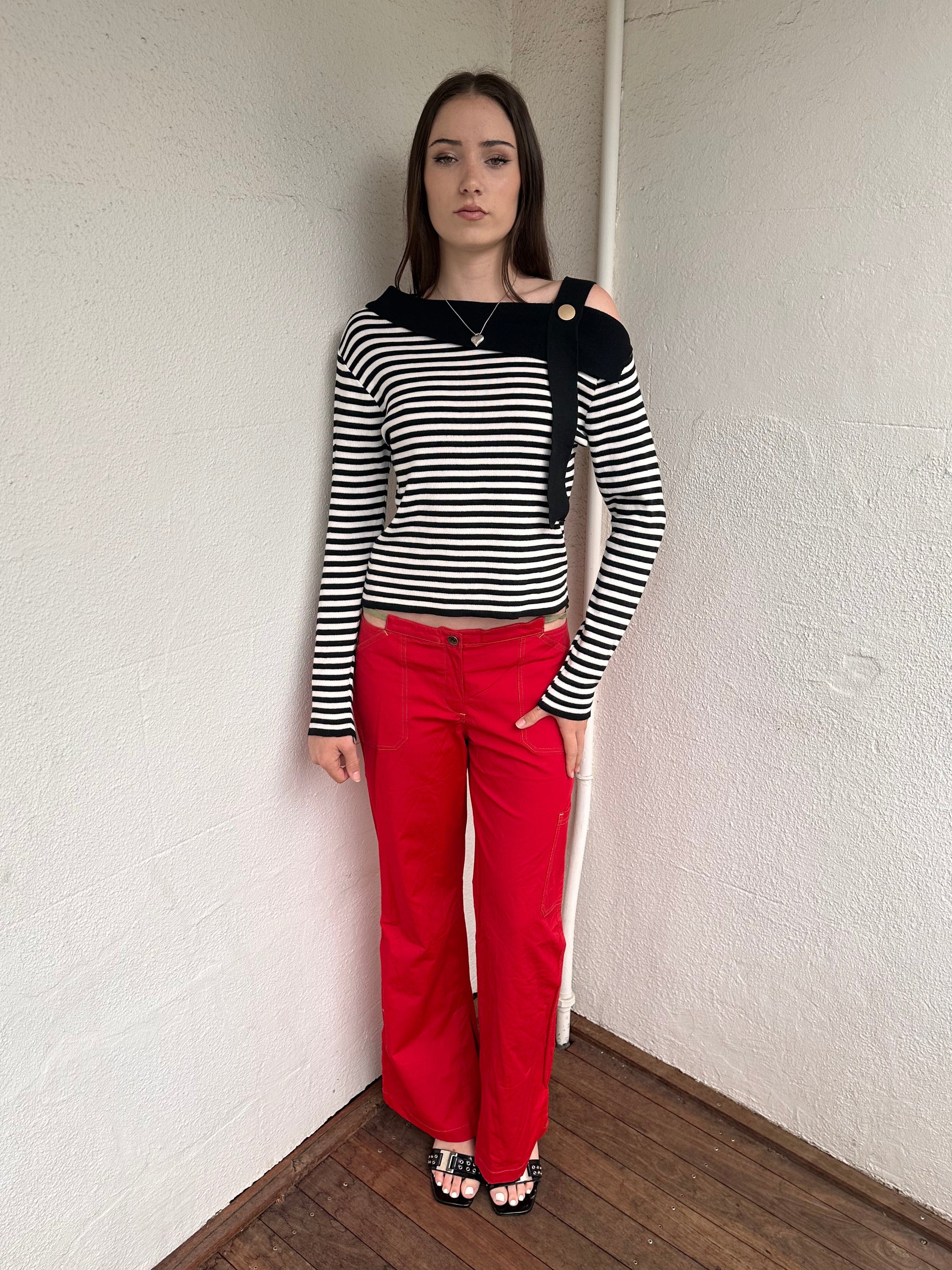 Women wearing a 00s Y2K lack and white stripe knitted top with an asymmetric collar and one-shoulder strap.
