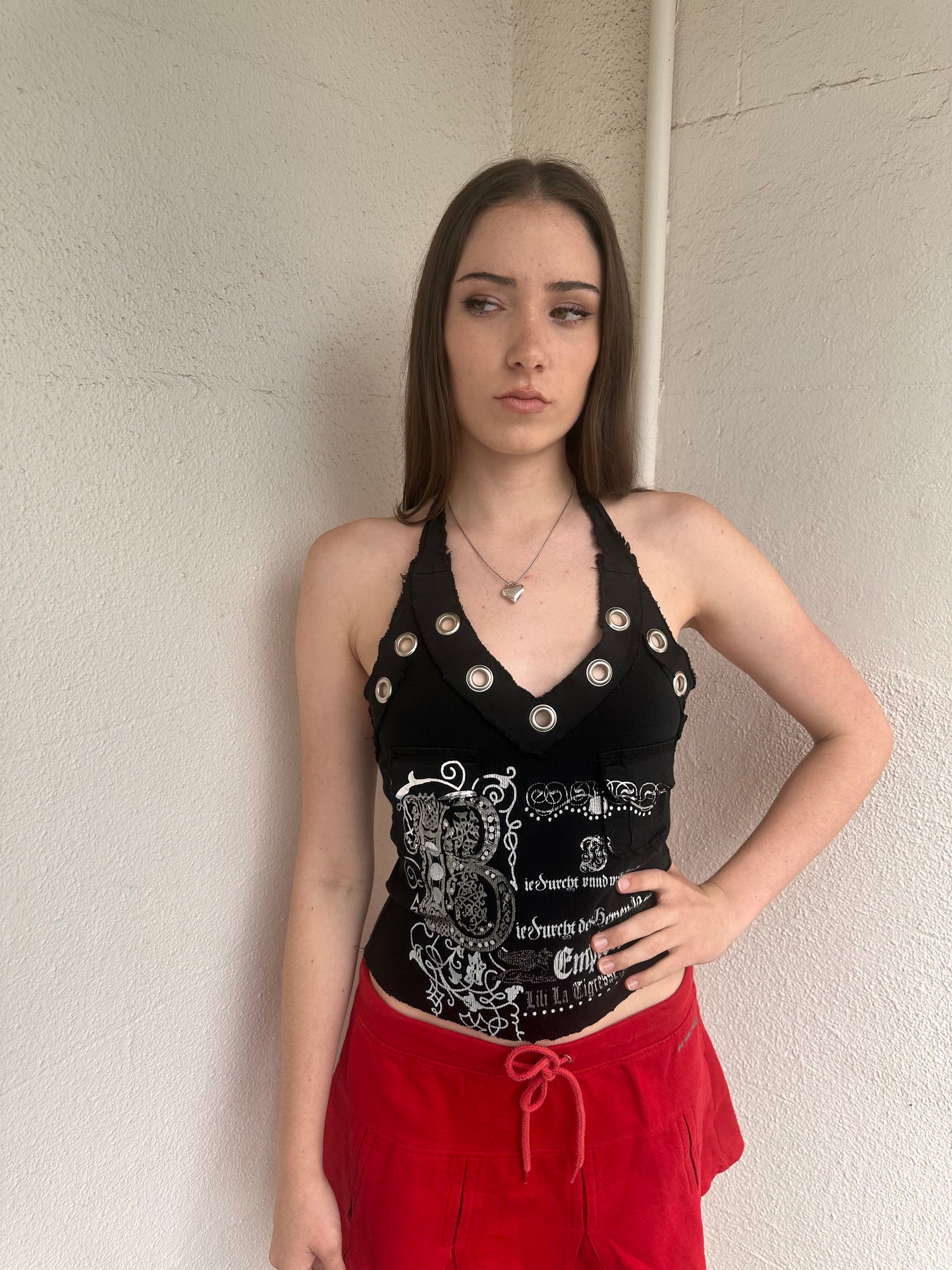 Woman wearing a Y2K 00s black grunge silver and white text graphic style halter top 