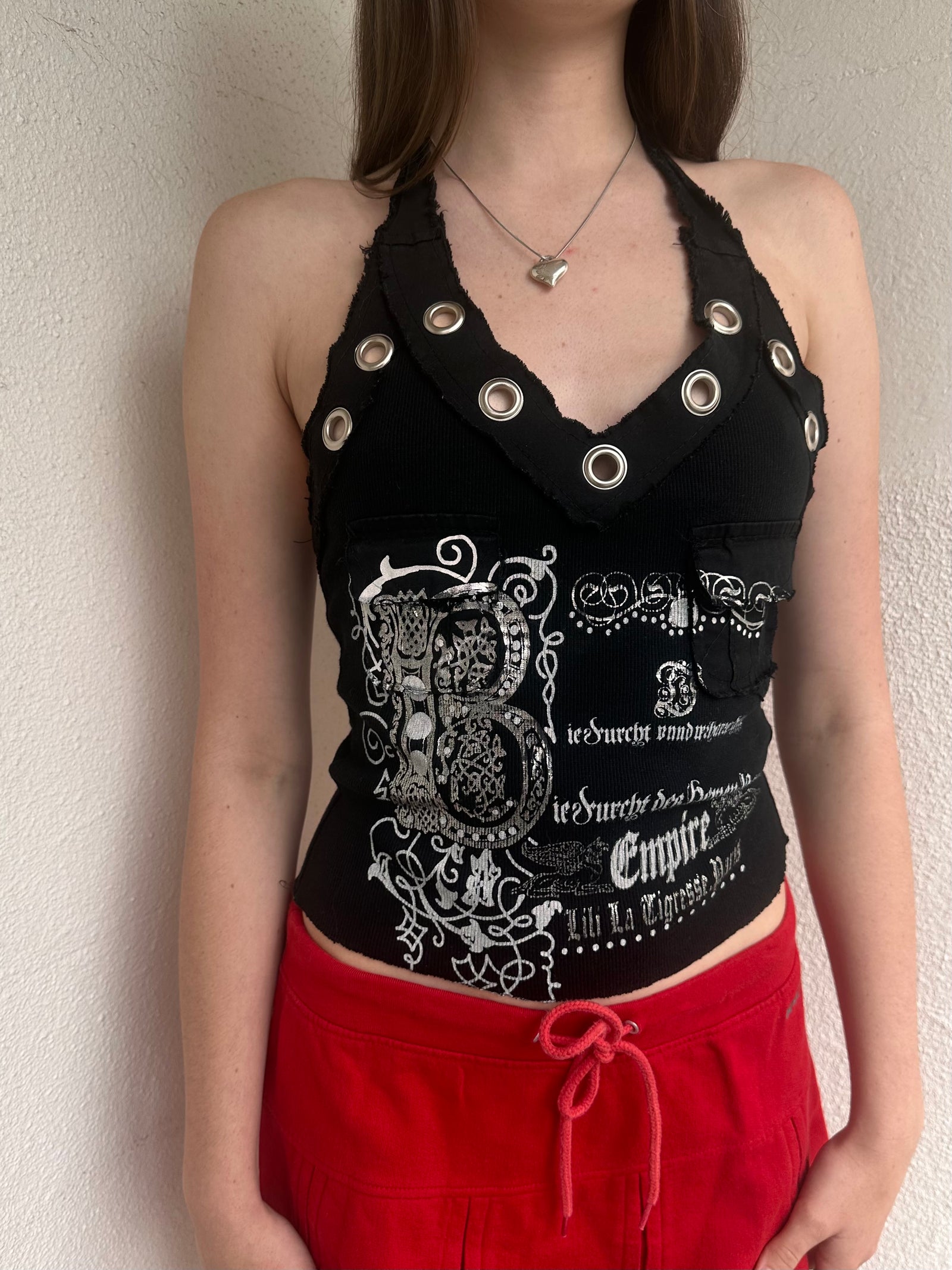 Woman wearing a Y2K 00s black grunge silver and white text graphic style halter top 
