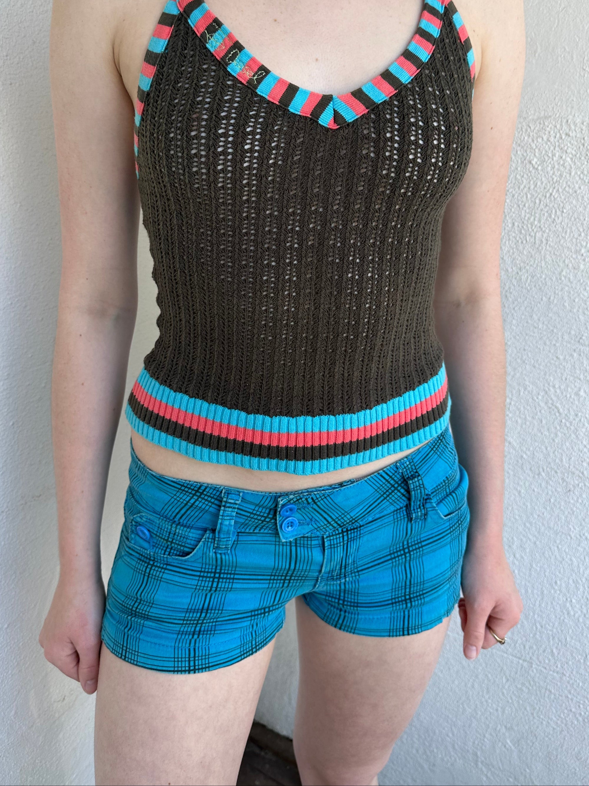 Woman Dressed in Y2K Blue and black plaid shorts featuring a bright blue base with black plaid detailing.