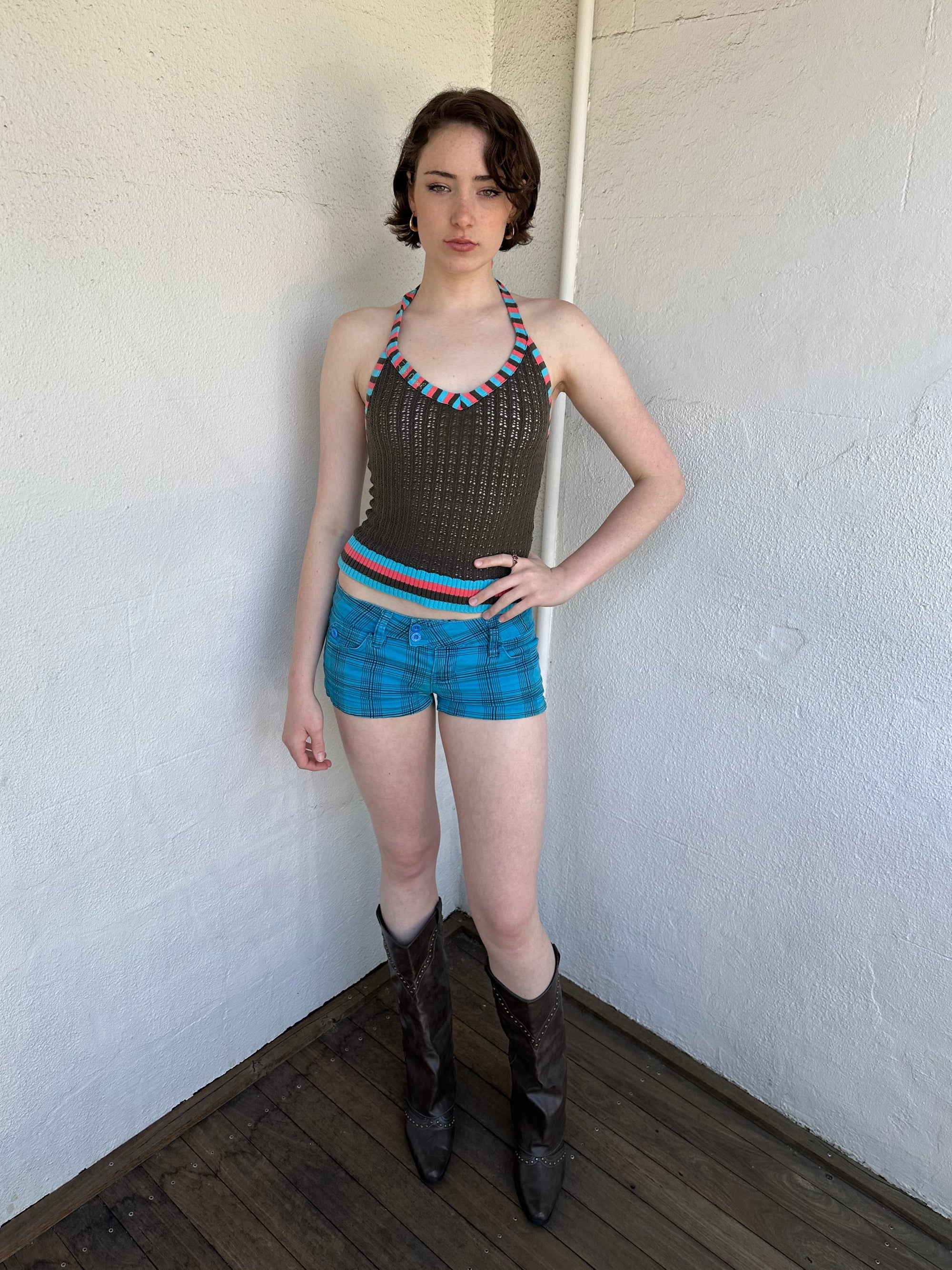 Woman Dressed in Y2K Blue and black plaid shorts featuring a bright blue base with black plaid detailing.