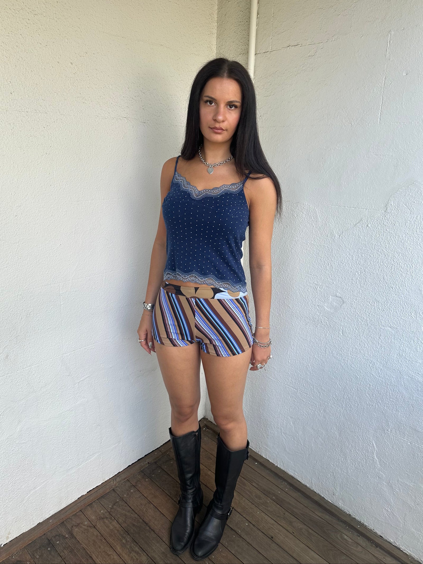 Woman Dressed in Y2K 00s Blue and brown stripe booty shorts featuring a multi-stripe pattern in brown, blue, and tan tones. 