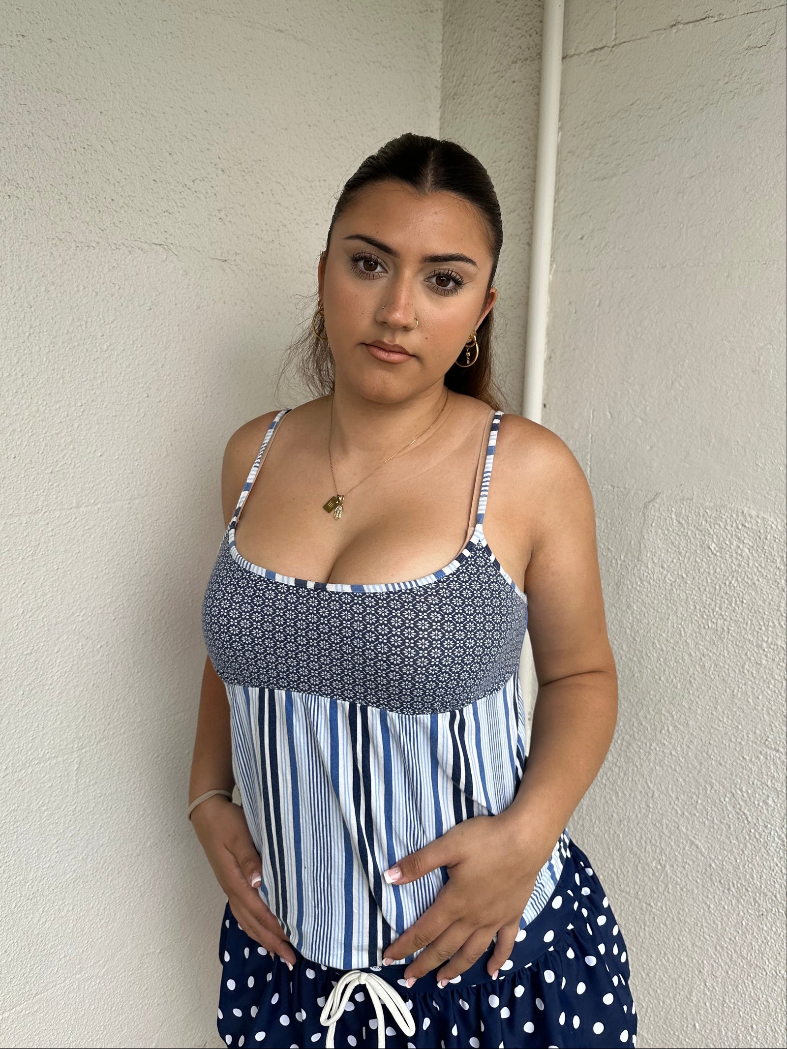 Woman Dressed in Y2K 00s Blue floral and stripe cami featuring a white and blue/navy floral bust with a striped base
