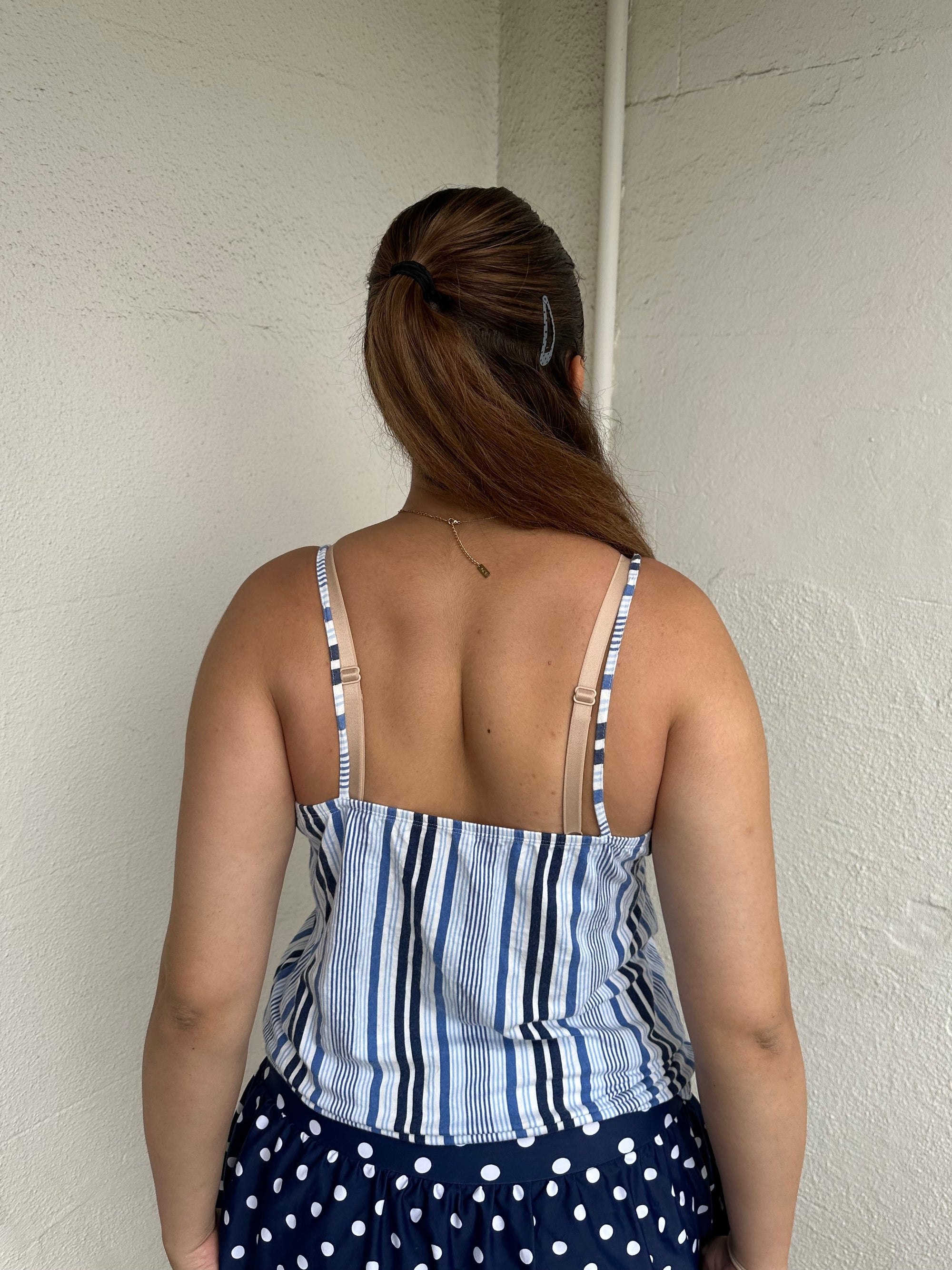 Woman Dressed in Y2K 00s Blue floral and stripe cami featuring a white and blue/navy floral bust with a striped base