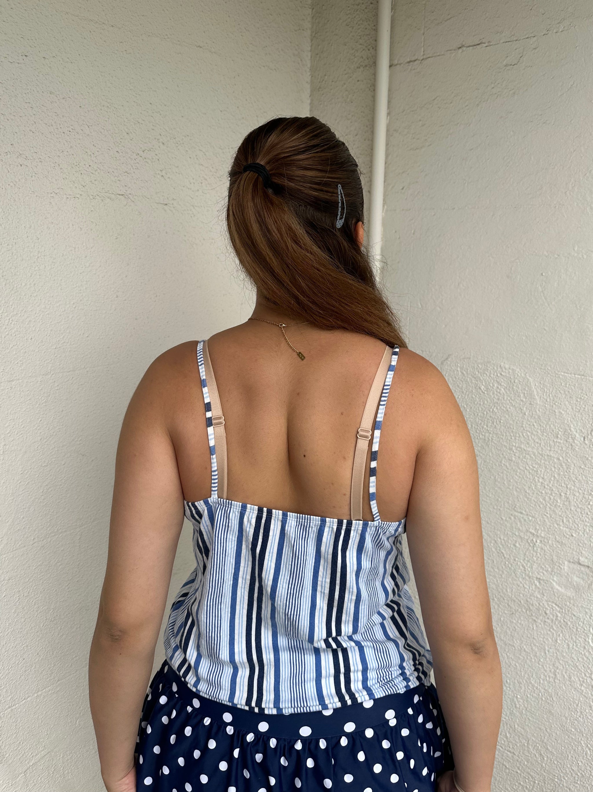 Woman Dressed in Y2K 00s Blue floral and stripe cami featuring a white and blue/navy floral bust with a striped base