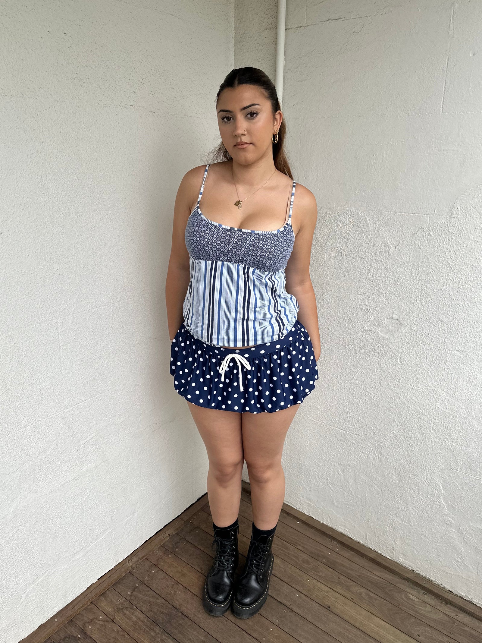 Woman Dressed in Y2K 00s Blue floral and stripe cami featuring a white and blue/navy floral bust with a striped base
