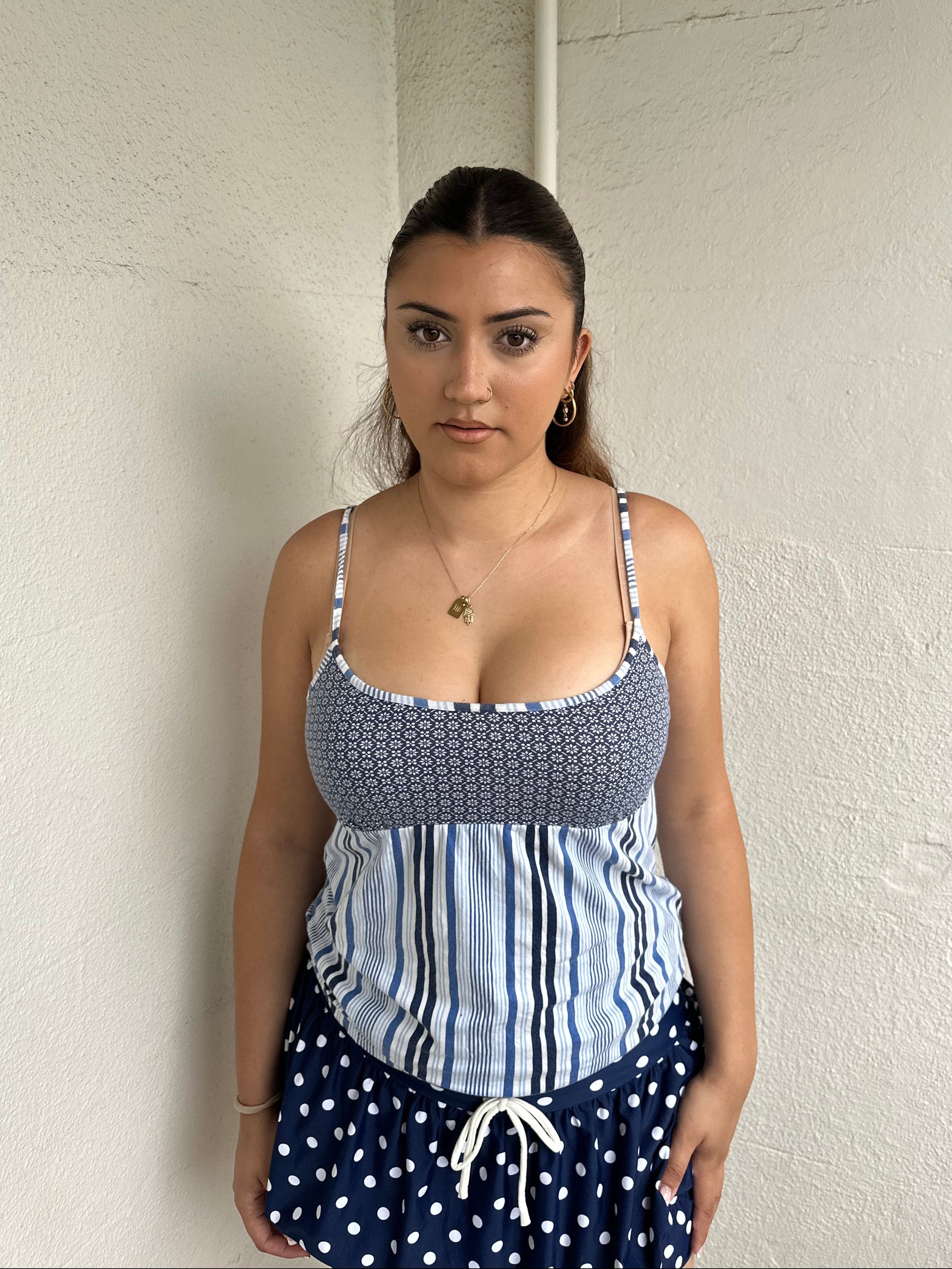Woman Dressed in Y2K 00s Blue floral and stripe cami featuring a white and blue/navy floral bust with a striped base.