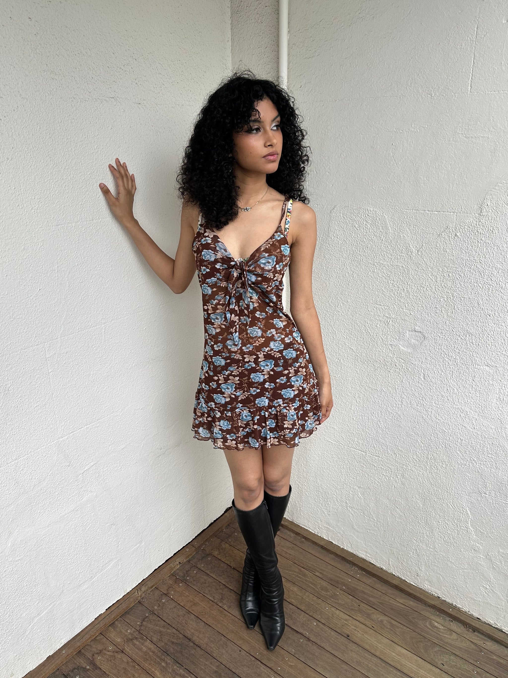 Woman Dressed in Y2K 00s Y2K Brown and blue floral mesh mini dress featuring a soft floral print in brown and blue tones throughout.