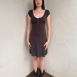 Woman wearing a Y2K 00s Brown and tiny blue polkadot milkmaid dress crafted from soft jersey fabric