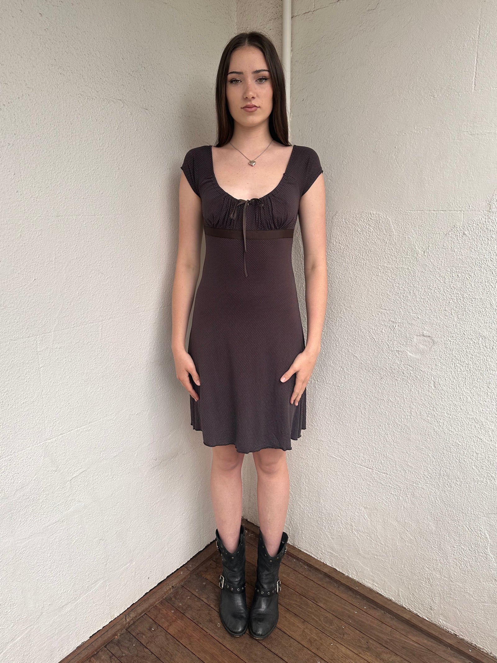 Woman wearing a Y2K 00s Brown and tiny blue polkadot milkmaid dress crafted from soft jersey fabric