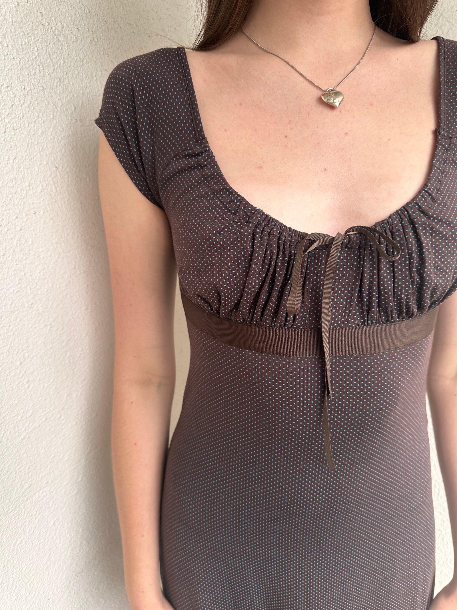 Woman wearing a Y2K 00s Brown and tiny blue polkadot milkmaid dress crafted from soft jersey fabric