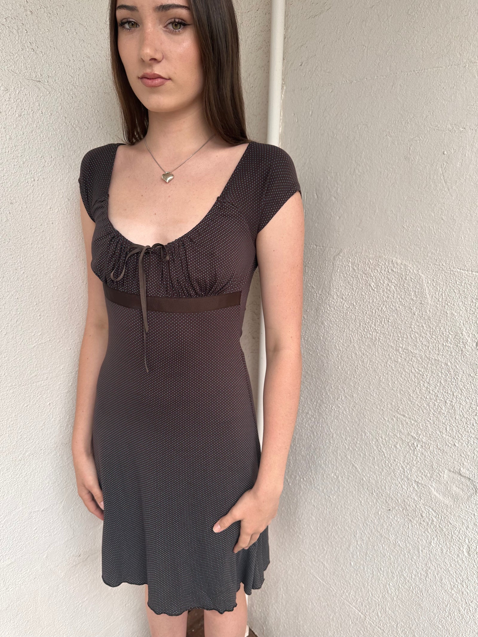 Woman wearing a Y2K 00s Brown and tiny blue polkadot milkmaid dress crafted from soft jersey fabric