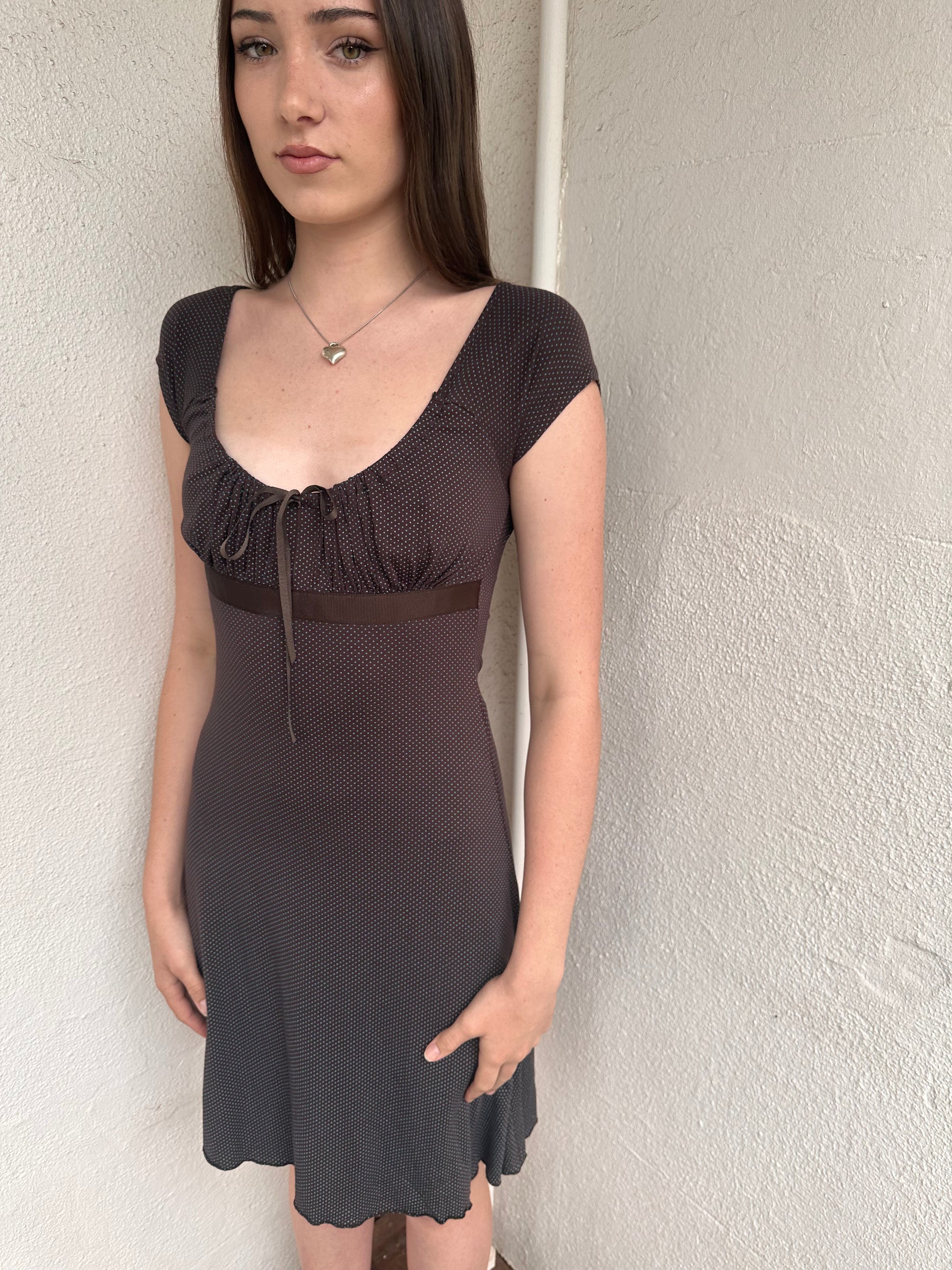Woman wearing a Y2K 00s Brown and tiny blue polkadot milkmaid dress crafted from soft jersey fabric