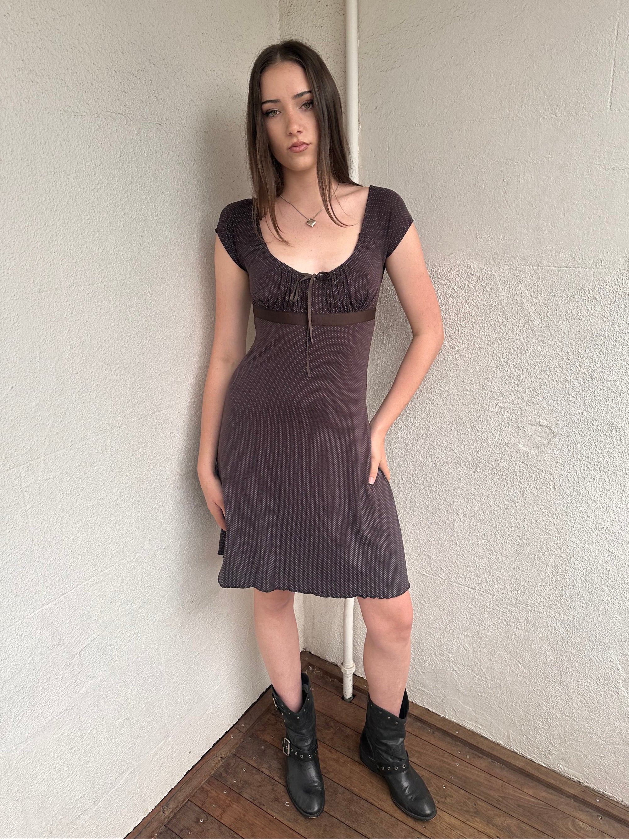 Woman wearing a Y2K 00s Brown and tiny blue polkadot milkmaid dress crafted from soft jersey fabric