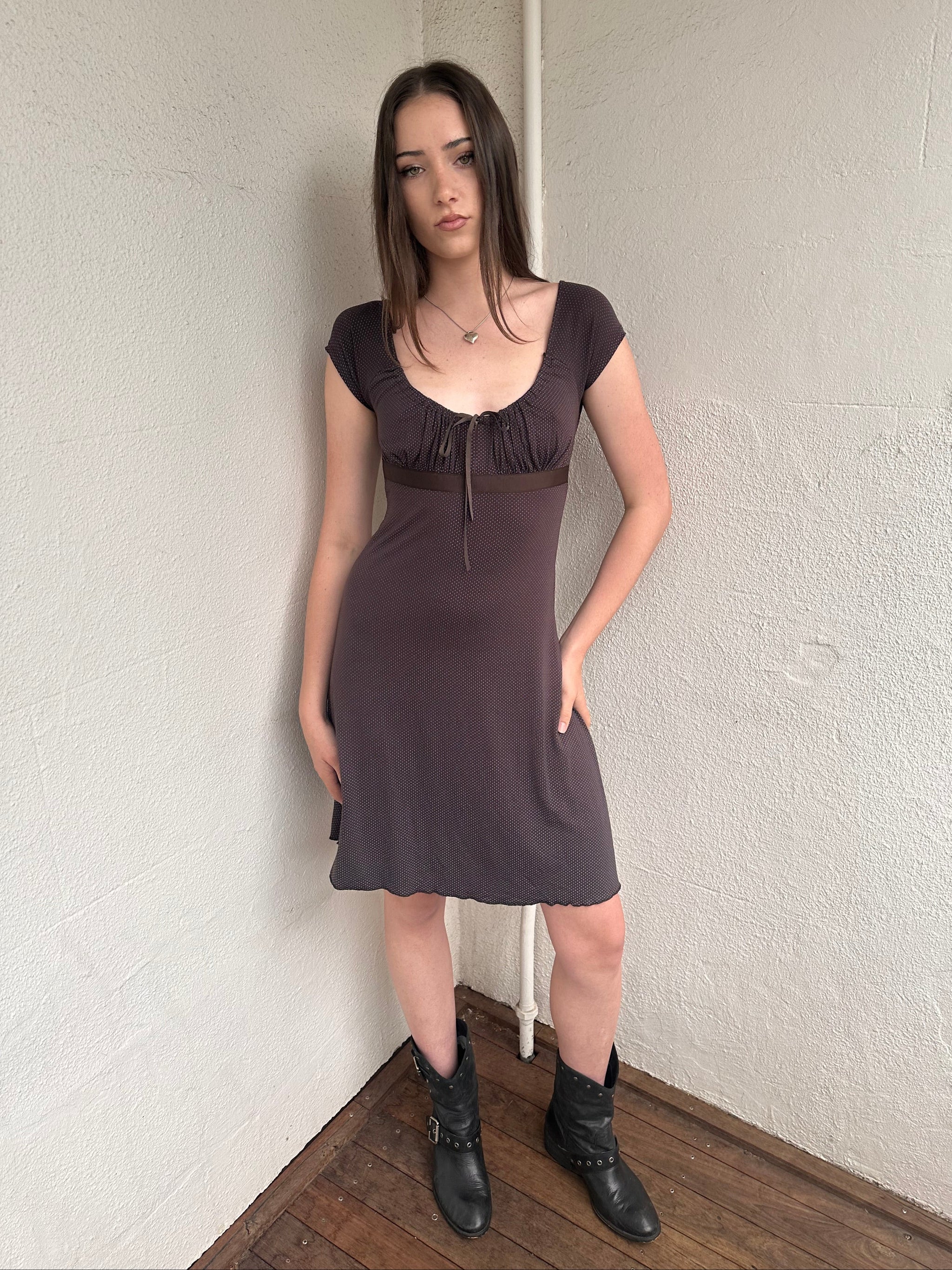 Woman wearing a Y2K 00s Brown and tiny blue polkadot milkmaid dress crafted from soft jersey fabric