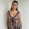 Woman Dressed in Y2K 00s Brown floral floaty tank top featuring a soft floral print with lace trim along the V neckline. 