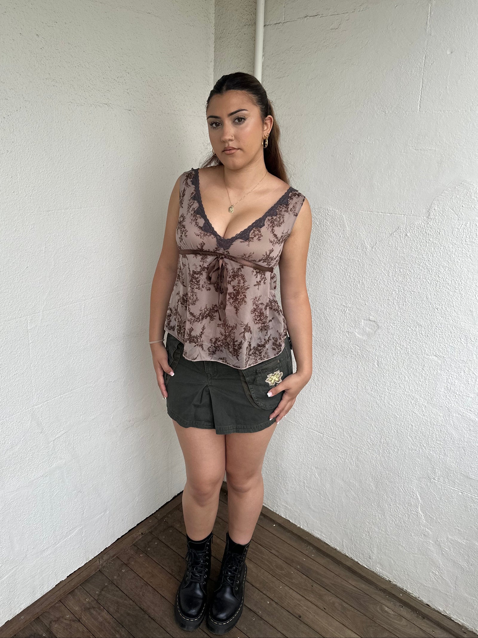 Woman Dressed in Y2K 00s Brown floral floaty tank top featuring a soft floral print with lace trim along the V neckline. 