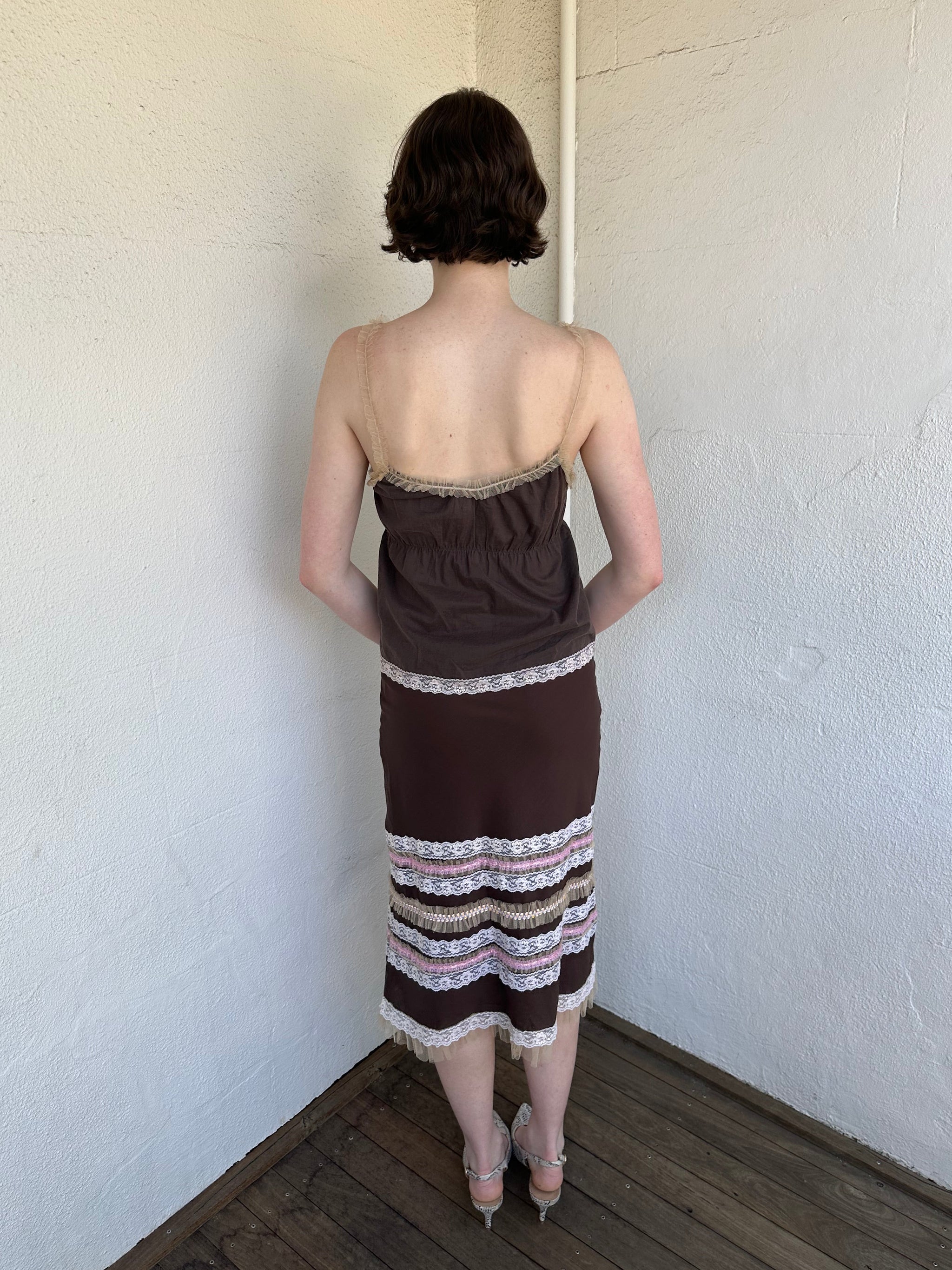 Woman Dressed in Y2K Brown and pink lace trim two piece set featuring a cami top and matching skirt detailed with cream lace and tulle trim throughout.