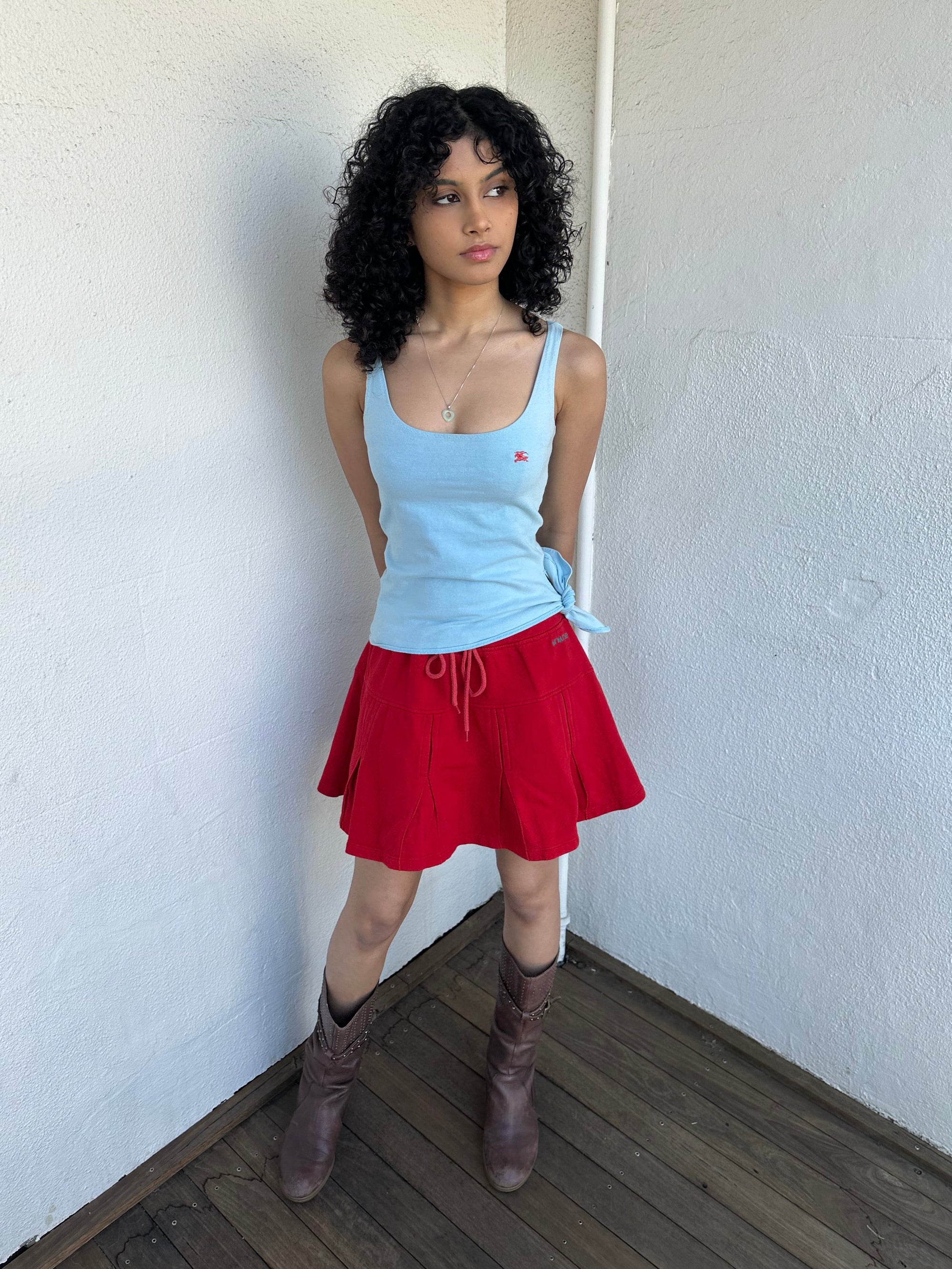 Women wearing a 00s Y2K Burberry baby blue tie cami from the 2000s featuring side tie and red embroidered logo. 
