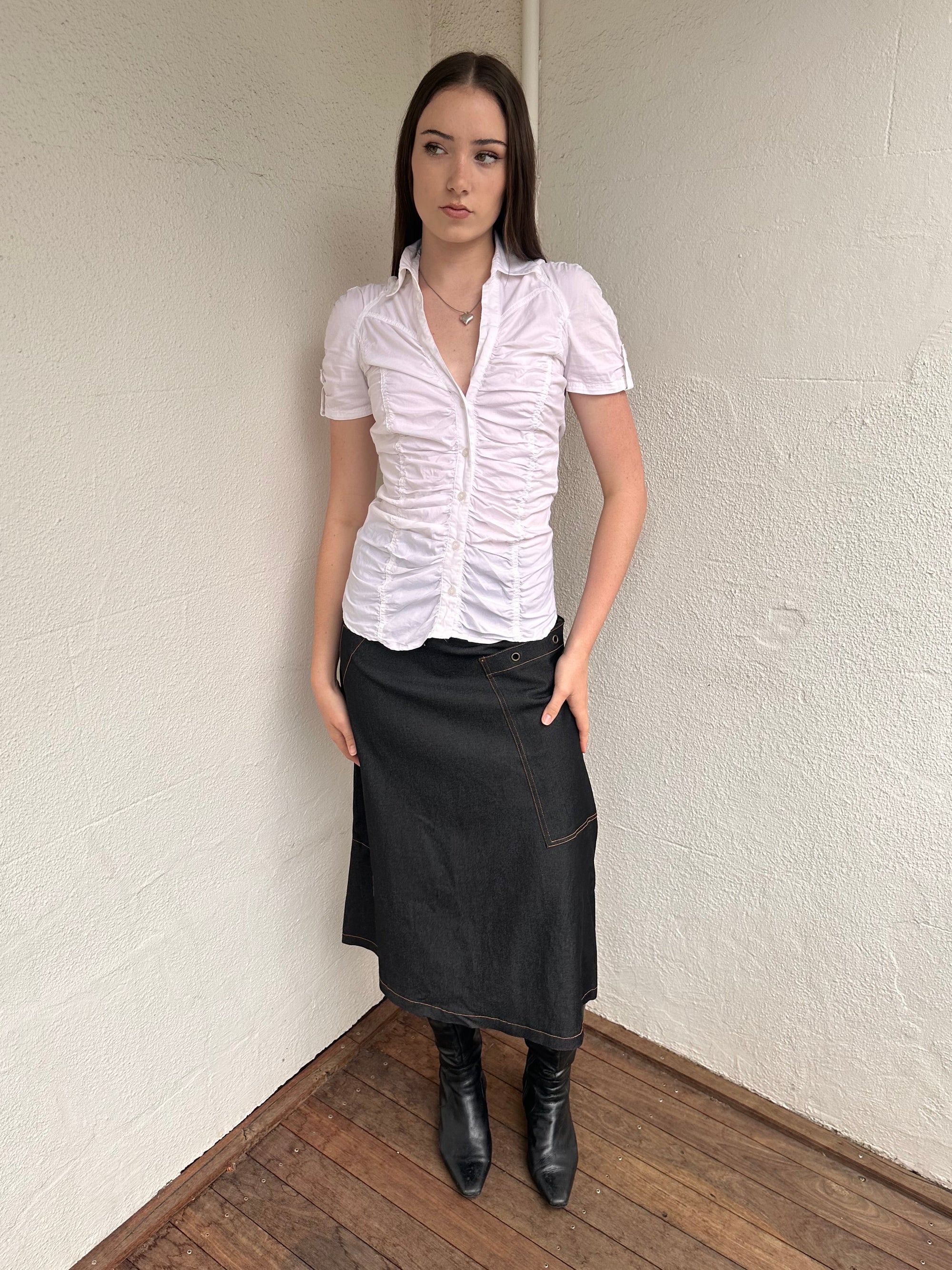 Woman wearing a Y2K 00s Cop Copine black maxi skirt stands out with bold orange contrast stitching and statement grommet details