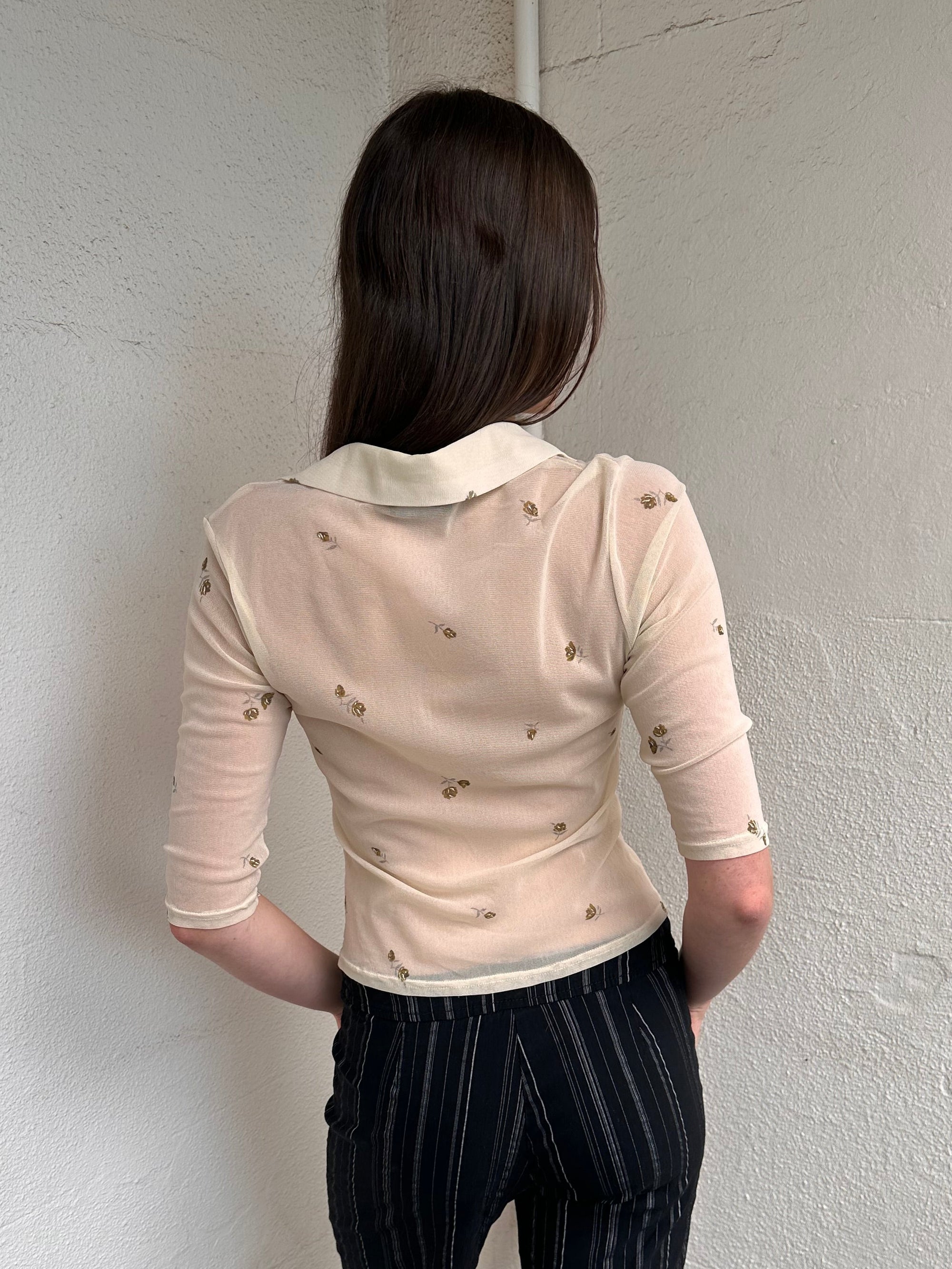 Women wearing a 00s Y2K Gorgeous 90s Cream floral mesh shirt with a cropped fit and 3/4 sleeves. 