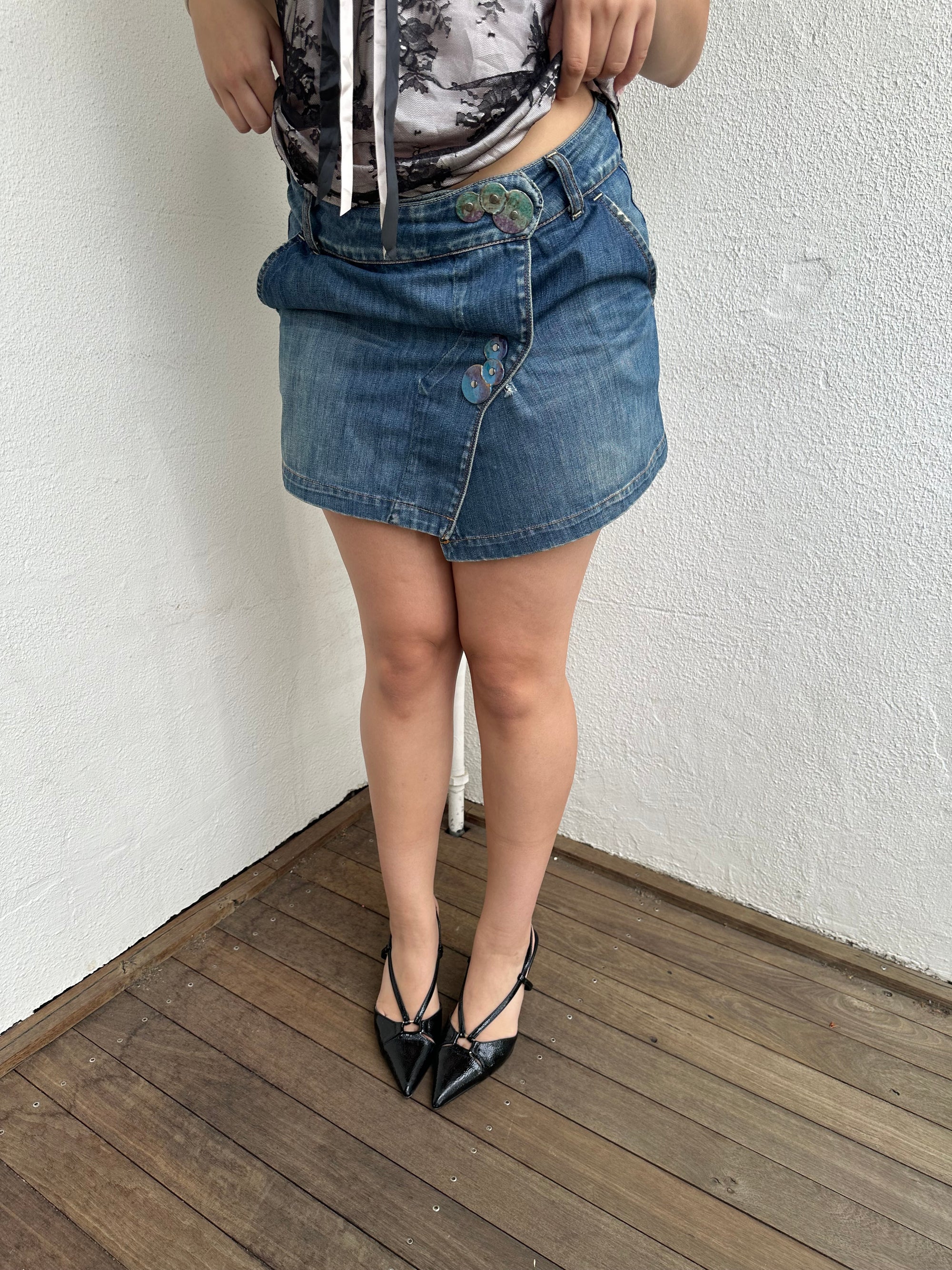Woman Dressed in Y2K Denim button front wrap mini skirt featuring a classic blue denim finish 