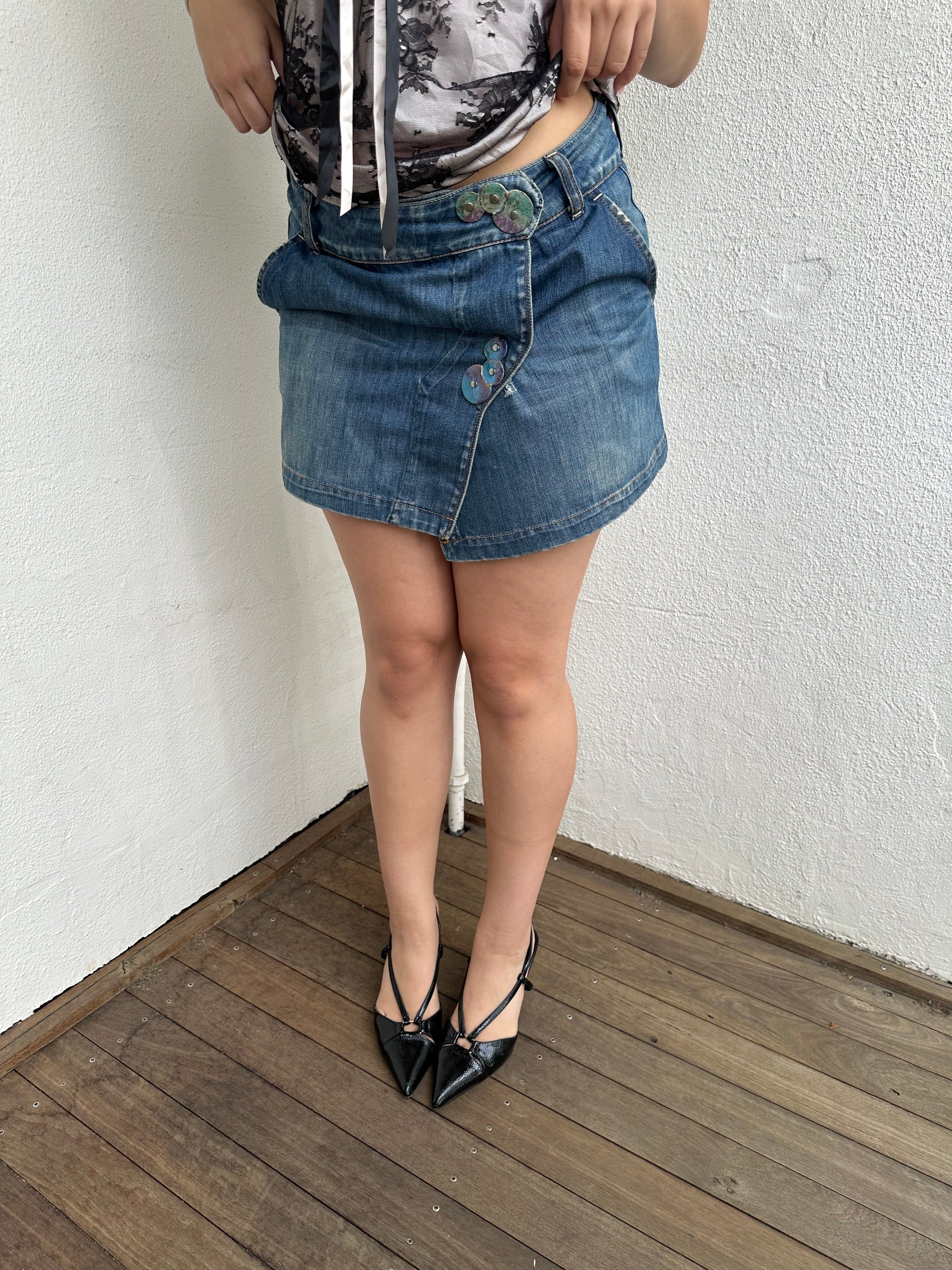 Woman Dressed in Y2K Denim button front wrap mini skirt featuring a classic blue denim finish 
