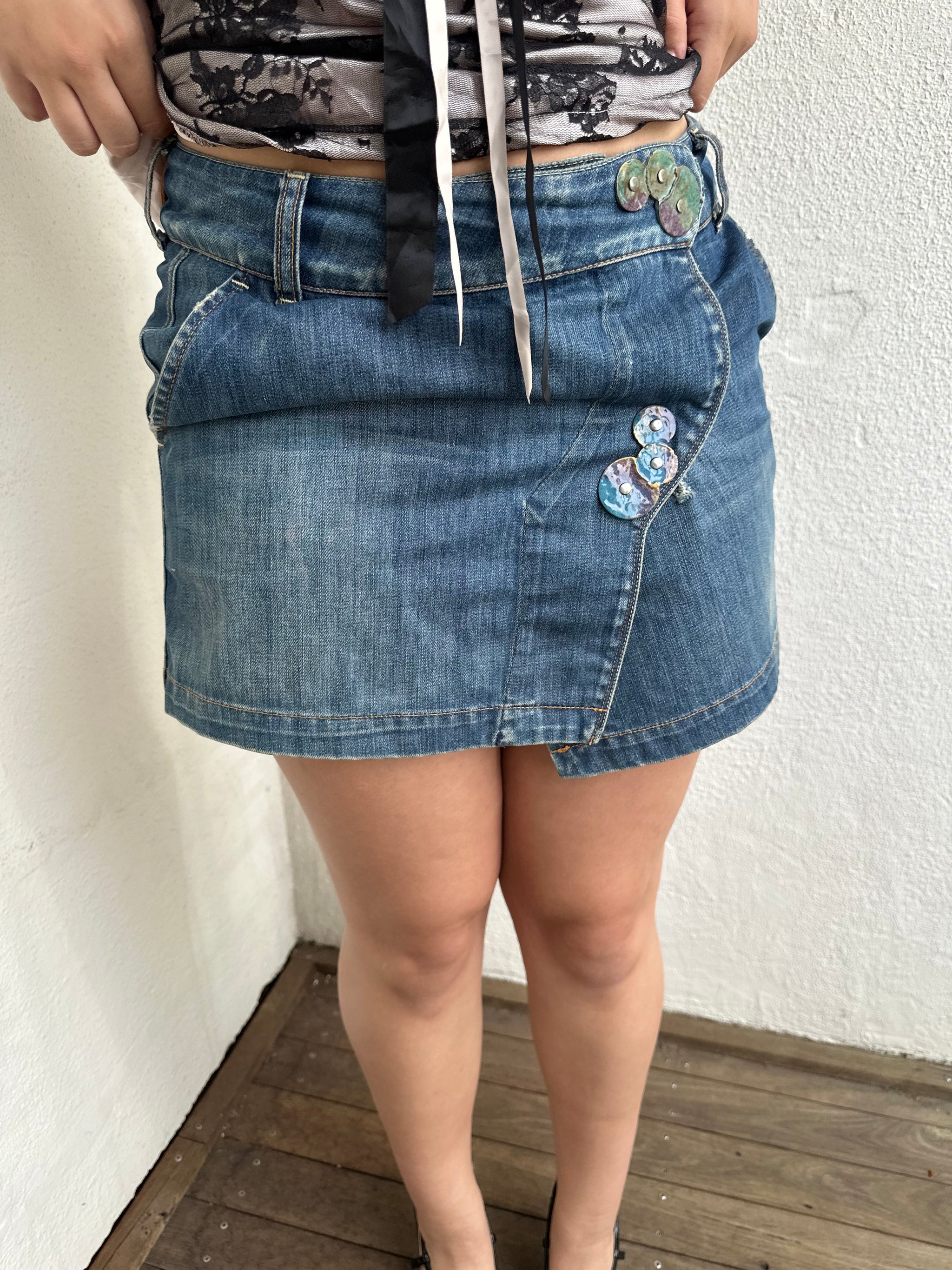 Woman Dressed in Y2K Denim button front wrap mini skirt featuring a classic blue denim finish 