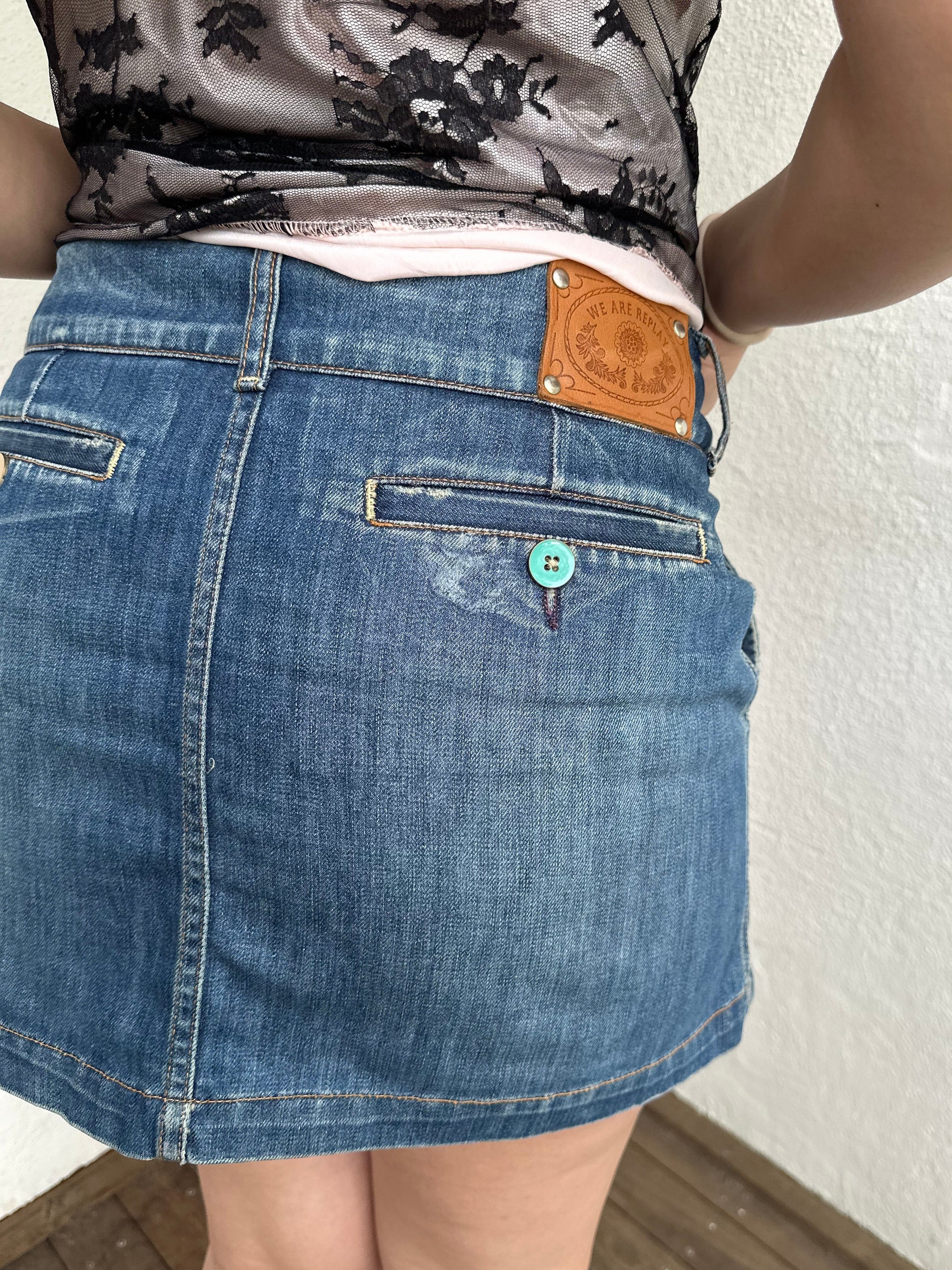 Woman Dressed in Y2K Denim button front wrap mini skirt featuring a classic blue denim finish 