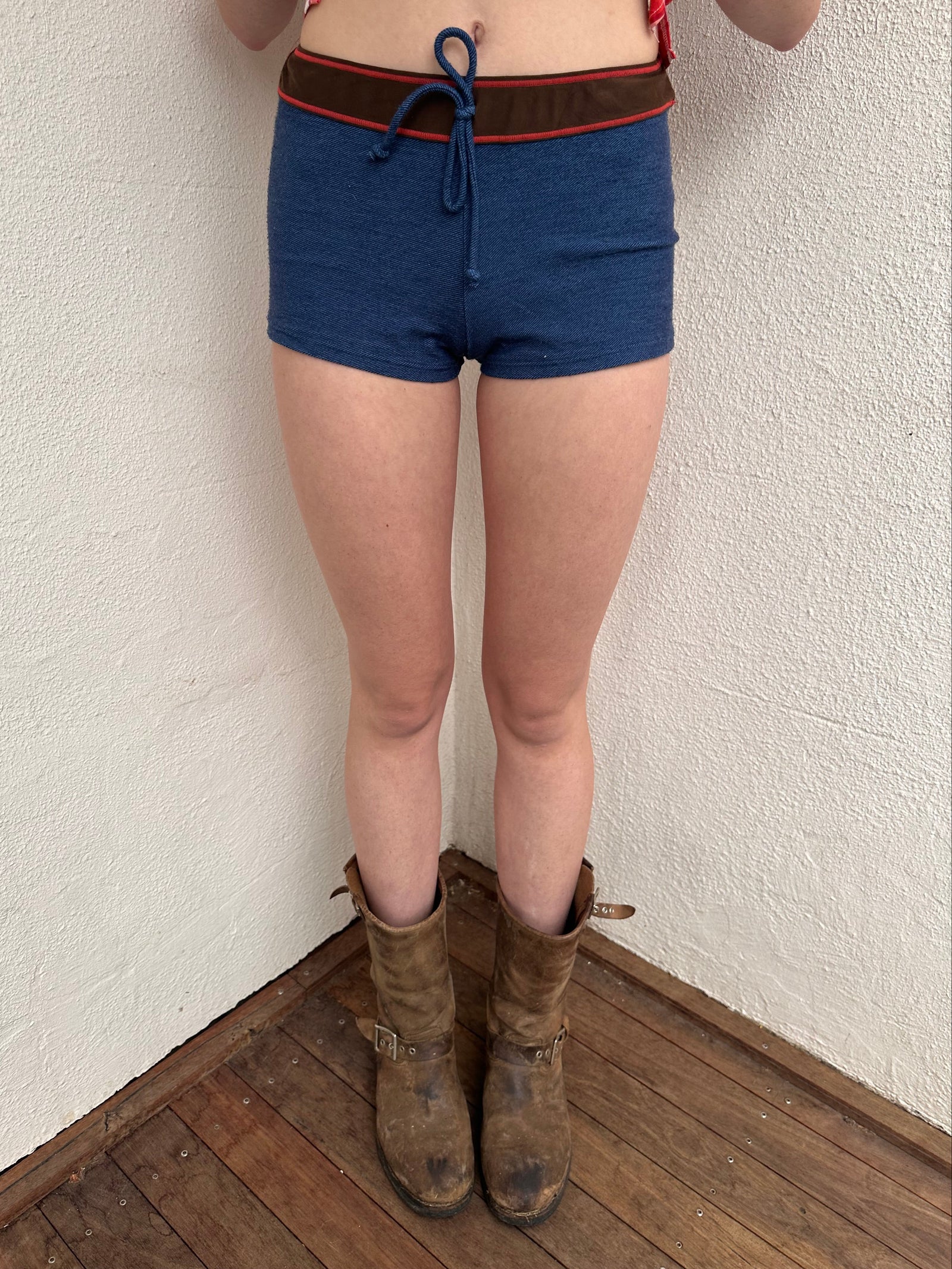 Woman wearing a Y2K 00s Denim look booty shorts feature bold red stitch detailing perfect for.a festival 