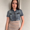 Woman wearing a Y2K 00s Mango washed out denim cropped jacket with a classic button-up front and structured fit