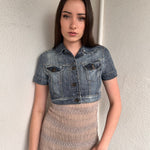 Woman wearing a Y2K 00s Mango washed out denim cropped jacket with a classic button-up front and structured fit