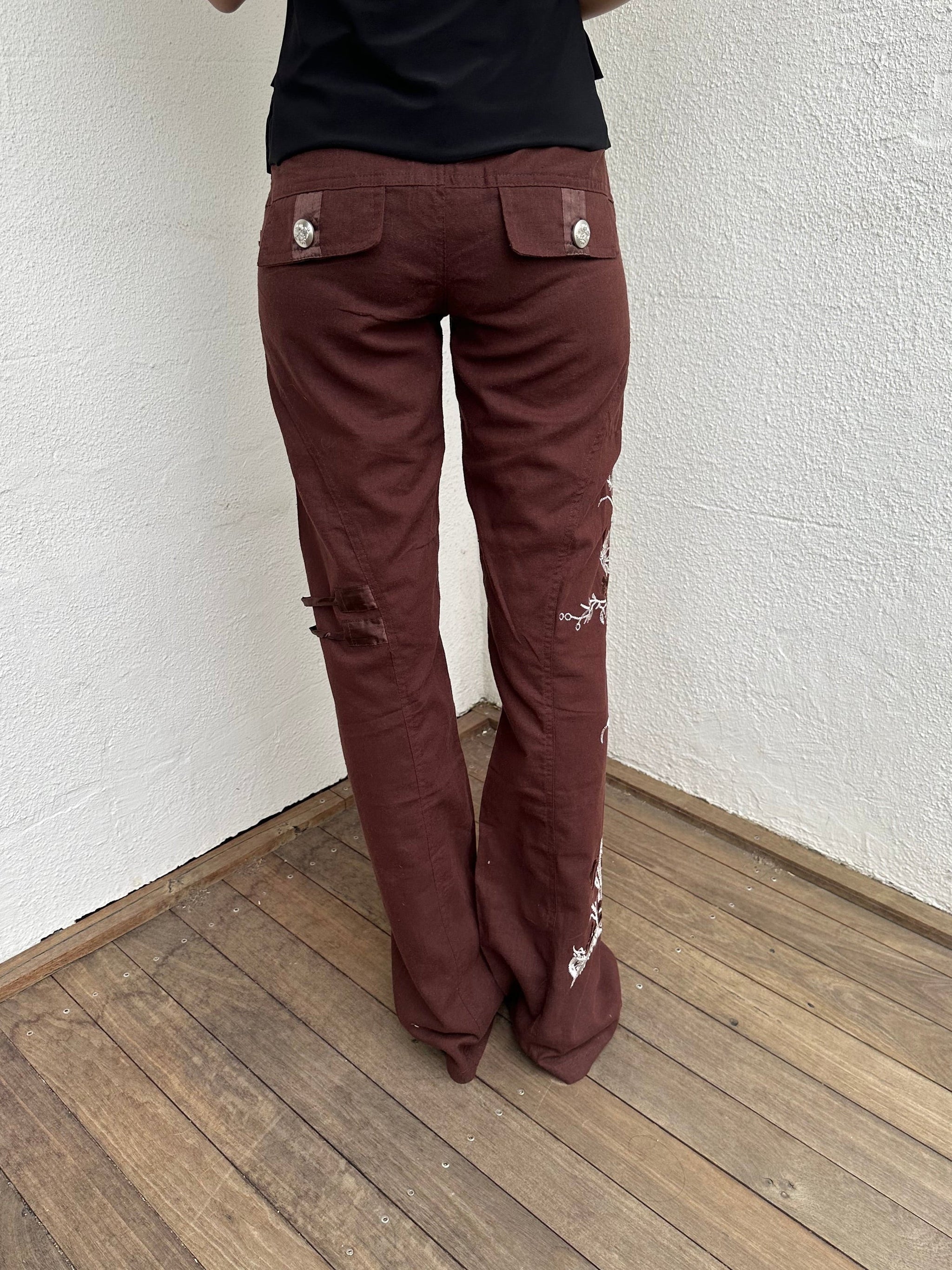 Woman Dressed in Y2K 00s Embroidery detail brown Y2K cargo pants featuring a rich brown tone with white floral leaf embroidery