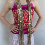 Woman Dressed in Y2K Gold sequin scarf featuring full sequin coverage with tassel ends.