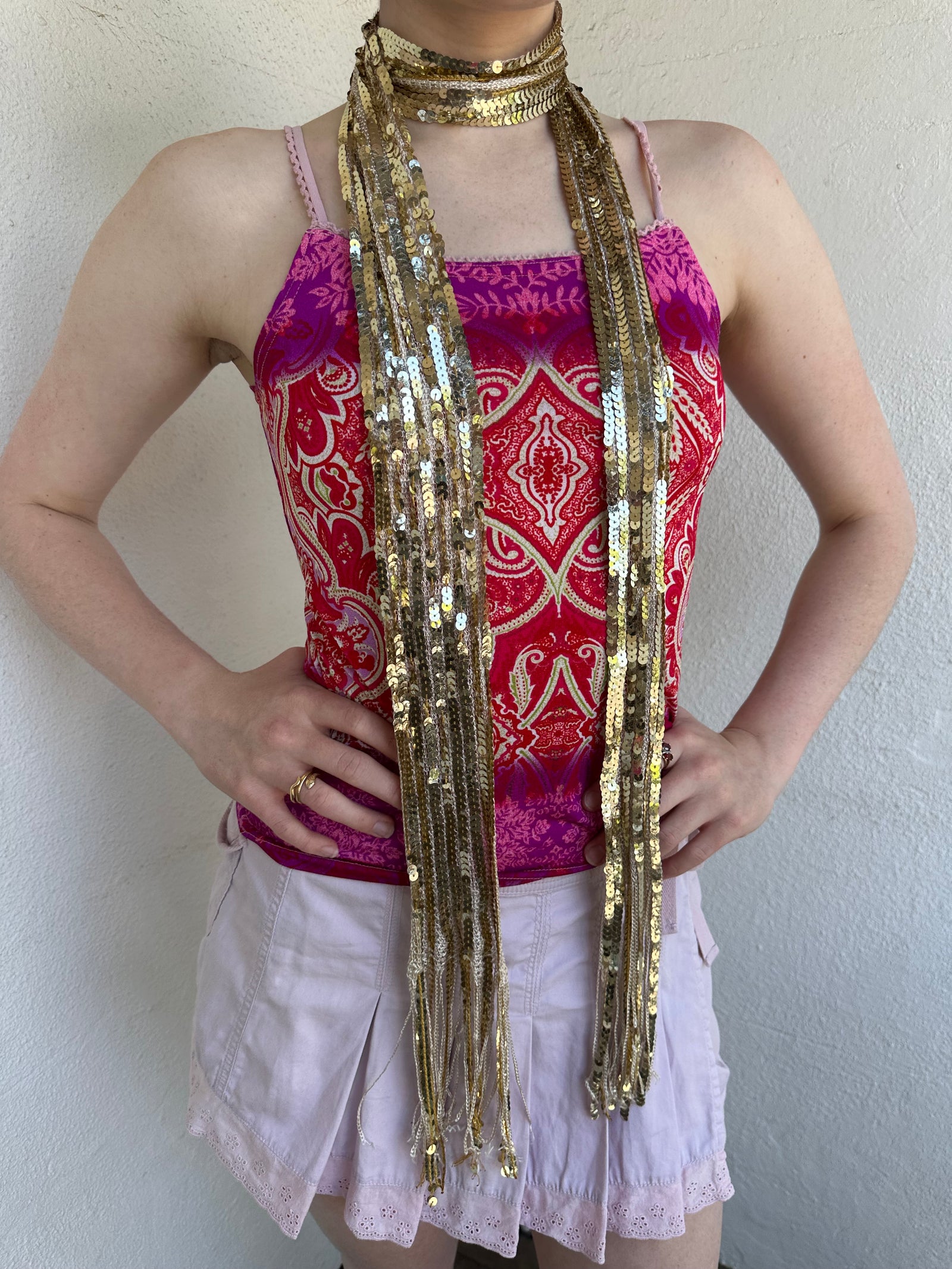 Woman Dressed in Y2K Gold sequin scarf featuring full sequin coverage with tassel ends.