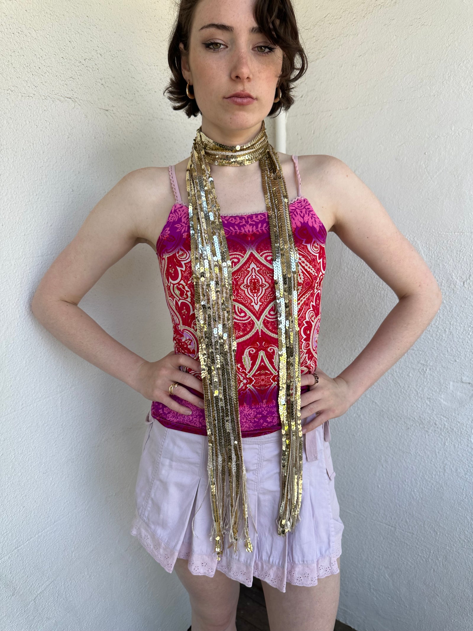 Woman Dressed in Y2K Gold sequin scarf featuring full sequin coverage with tassel ends.