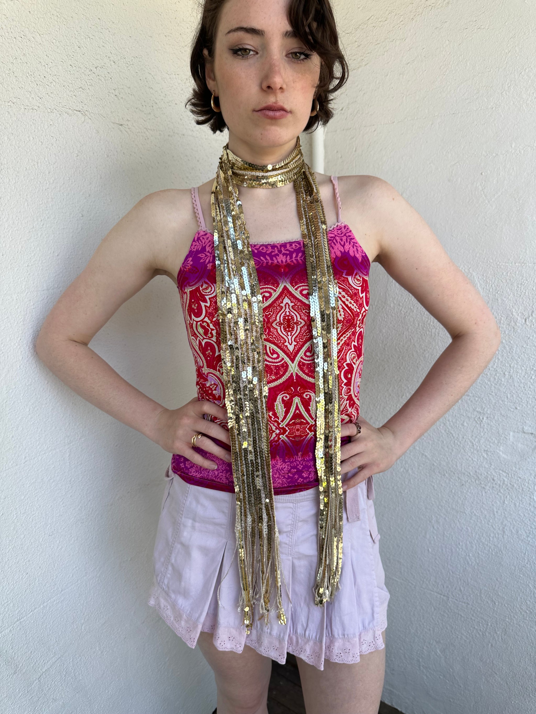 Woman Dressed in Y2K Gold sequin scarf featuring full sequin coverage with tassel ends.