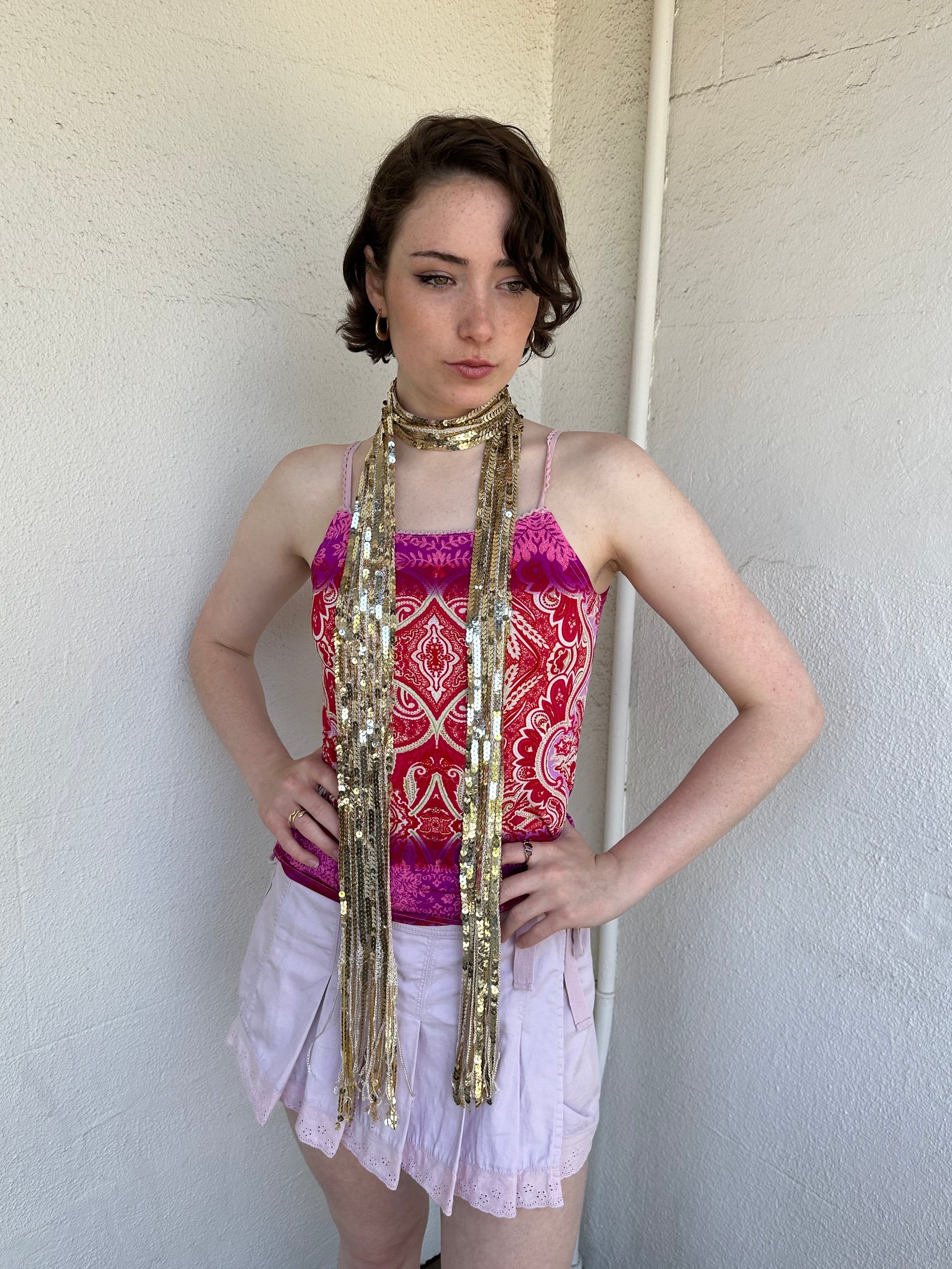 Woman Dressed in Y2K Gold sequin scarf featuring full sequin coverage with tassel ends.