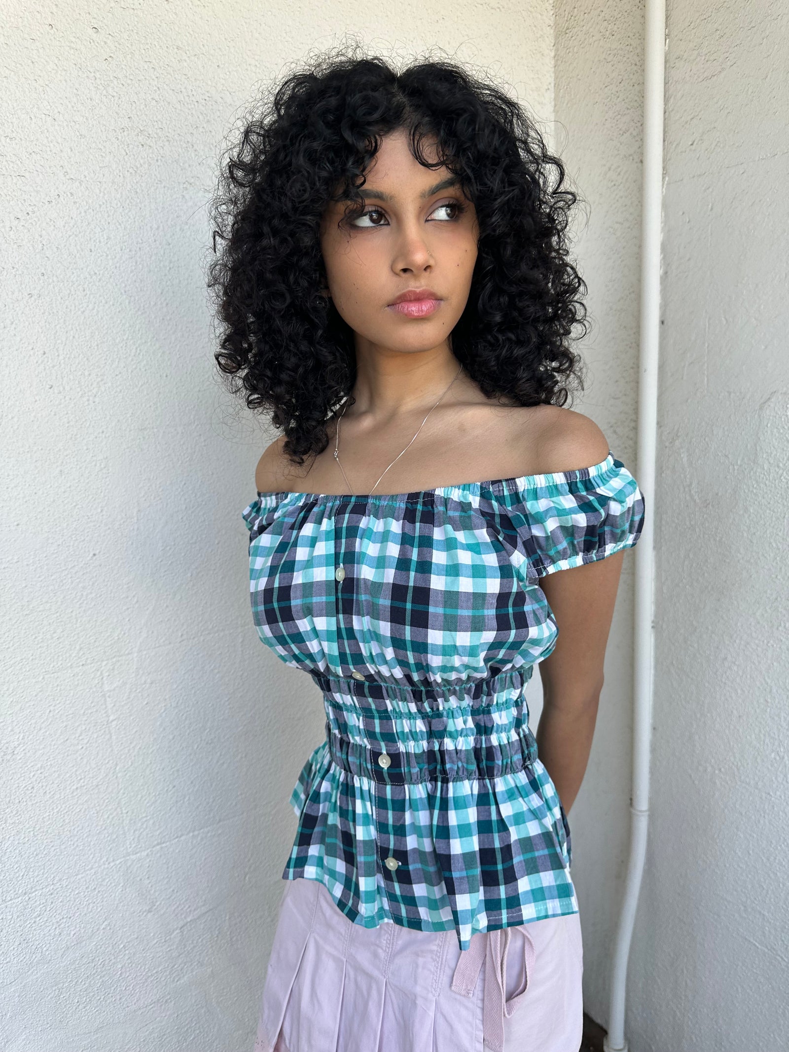 Woman wearing a Y2K 90s reworked vintage shirt transformed into a summer classic green and blue check milkmaid style top