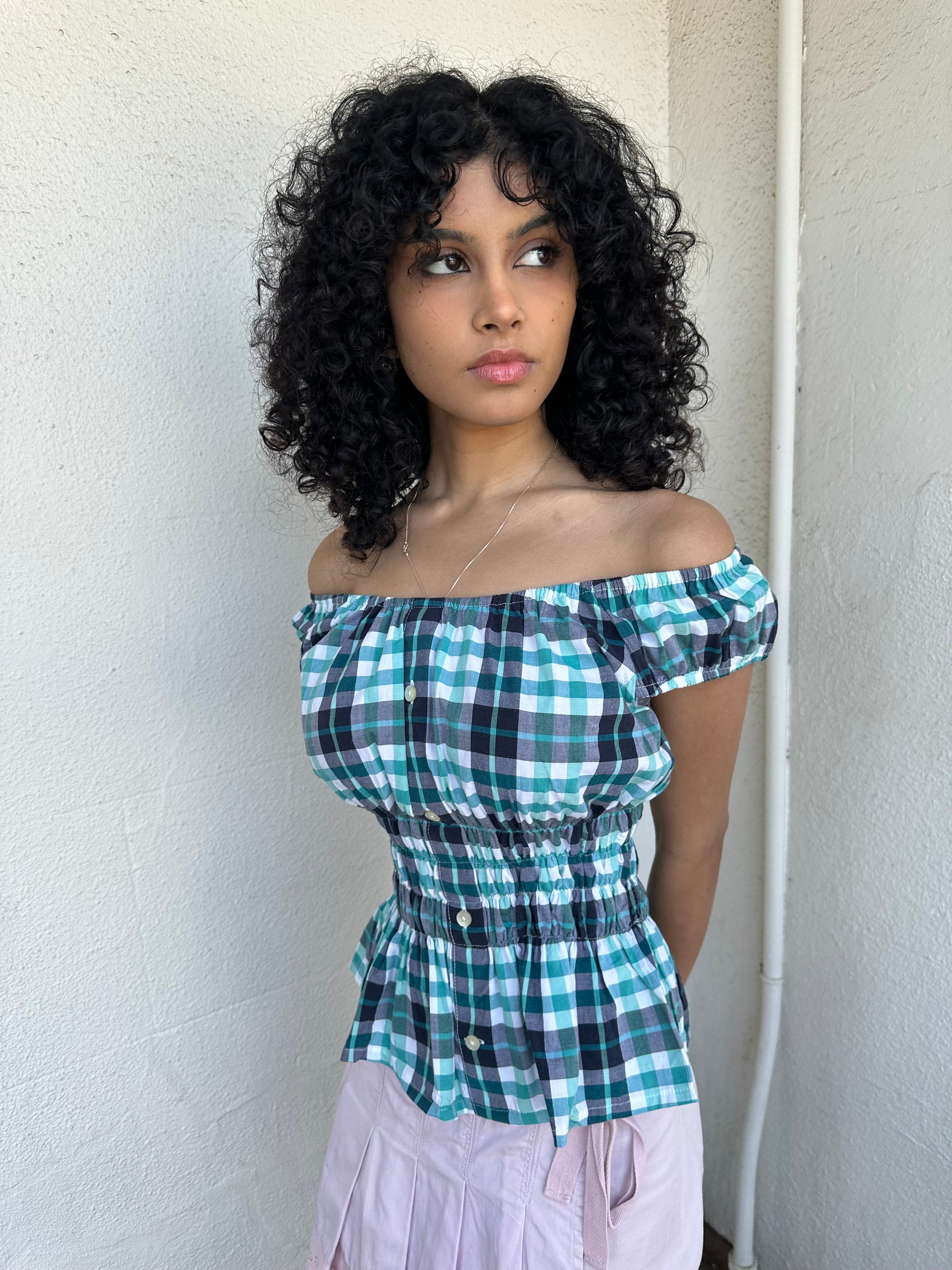 Woman wearing a Y2K 90s reworked vintage shirt transformed into a summer classic green and blue check milkmaid style top