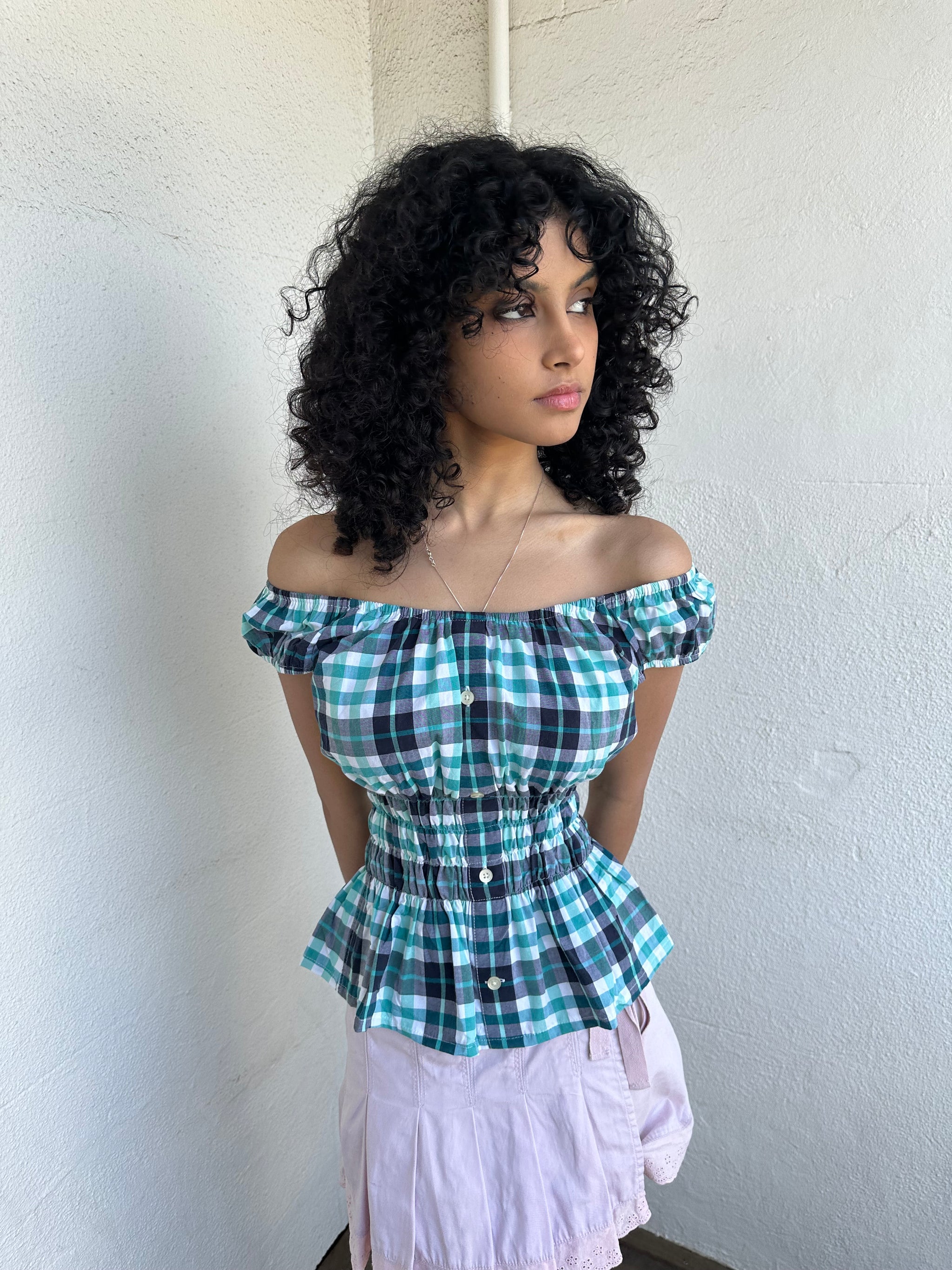 Woman wearing a Y2K 90s reworked vintage shirt transformed into a summer classic green and blue check milkmaid style top