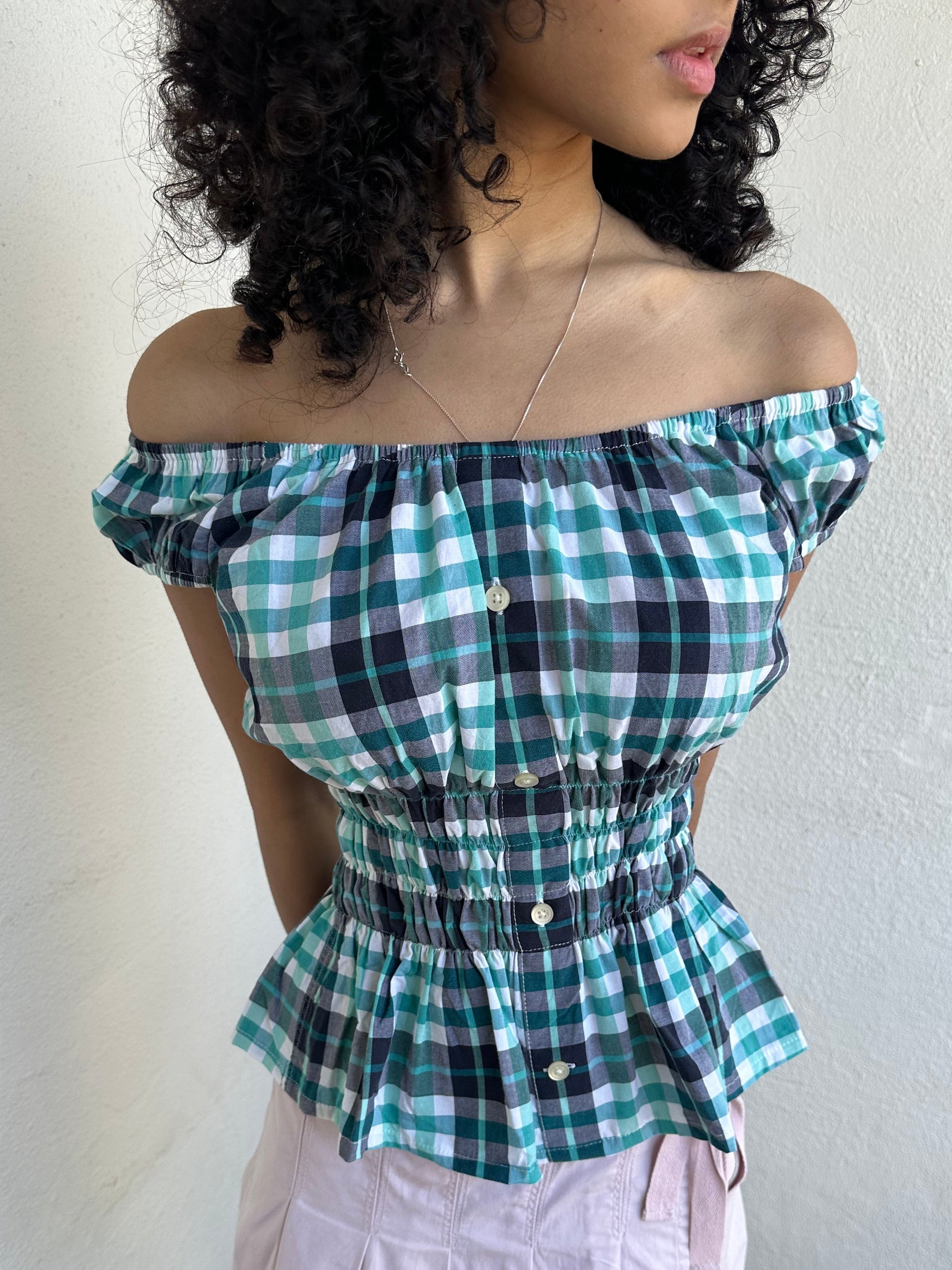 Woman wearing a Y2K 90s reworked vintage shirt transformed into a summer classic green and blue check milkmaid style top