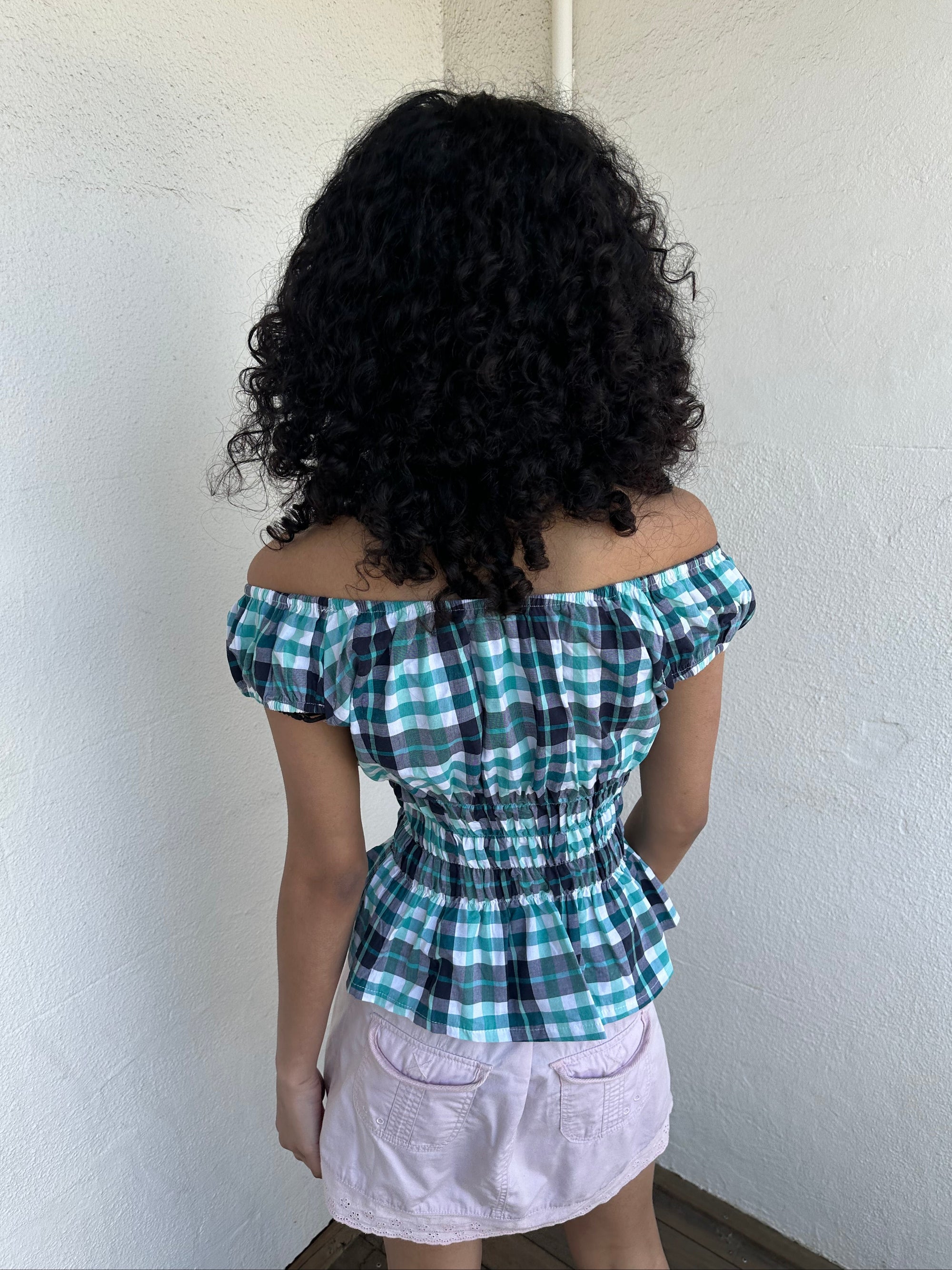 Woman wearing a Y2K 90s reworked vintage shirt transformed into a summer classic green and blue check milkmaid style top