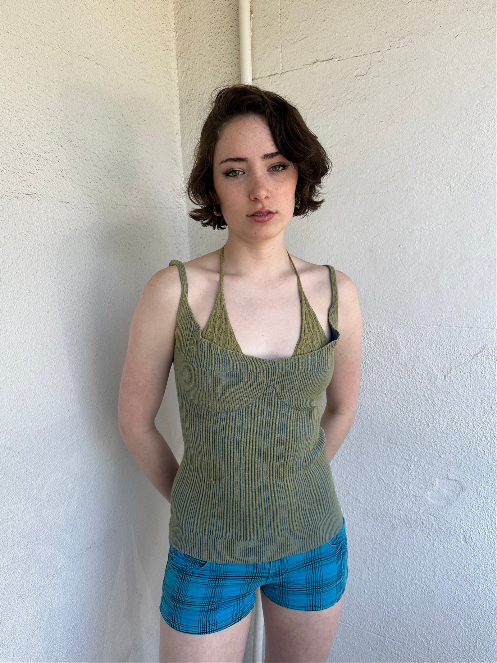 Woman Dressed in Y2K Green and blue layered knitted top featuring a two-toned blue and green ribbed knit.